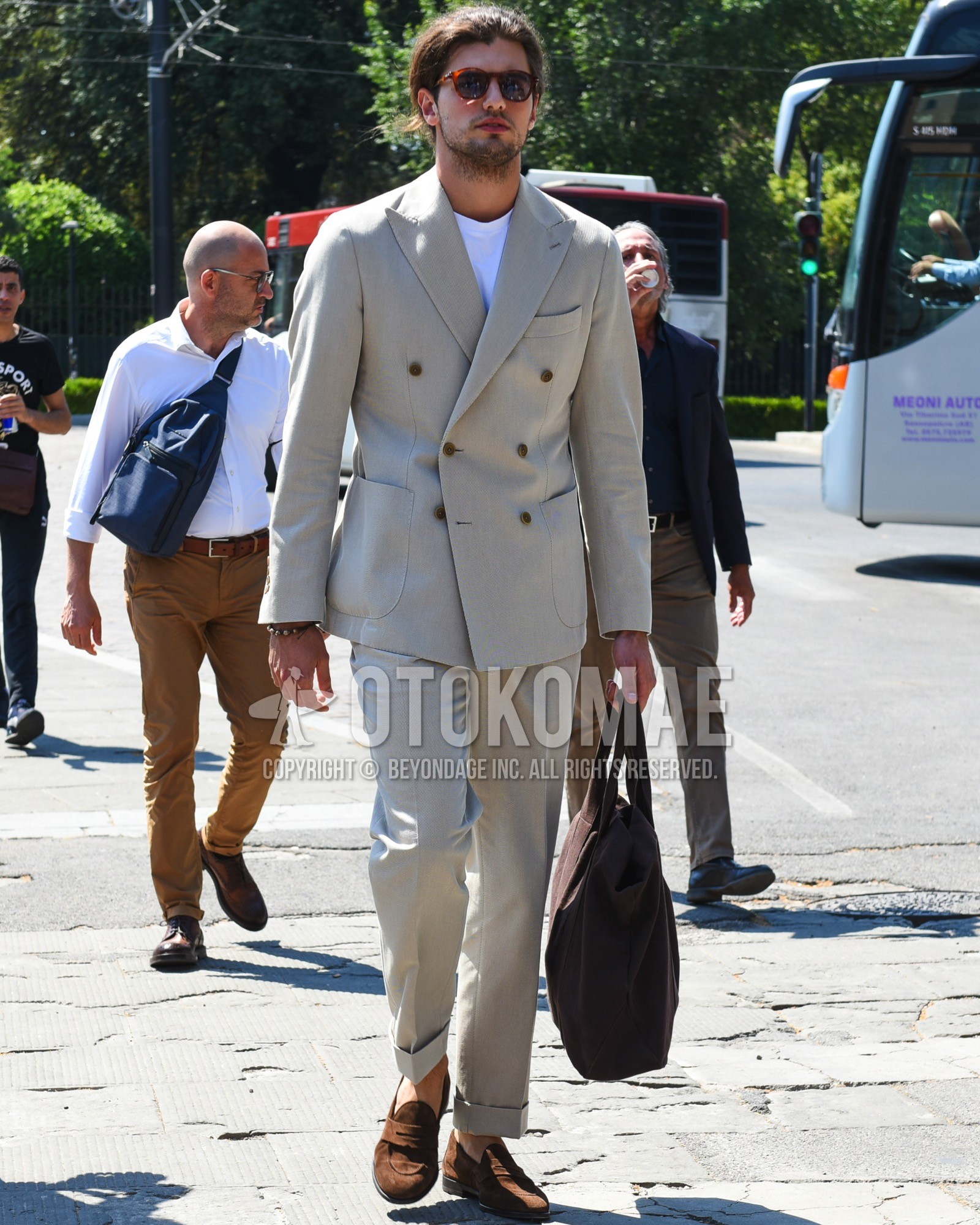 Men's spring summer outfit with brown tortoiseshell sunglasses, white plain t-shirt, brown coin loafers leather shoes, brown suede shoes leather shoes, brown plain briefcase/handbag, beige plain suit.