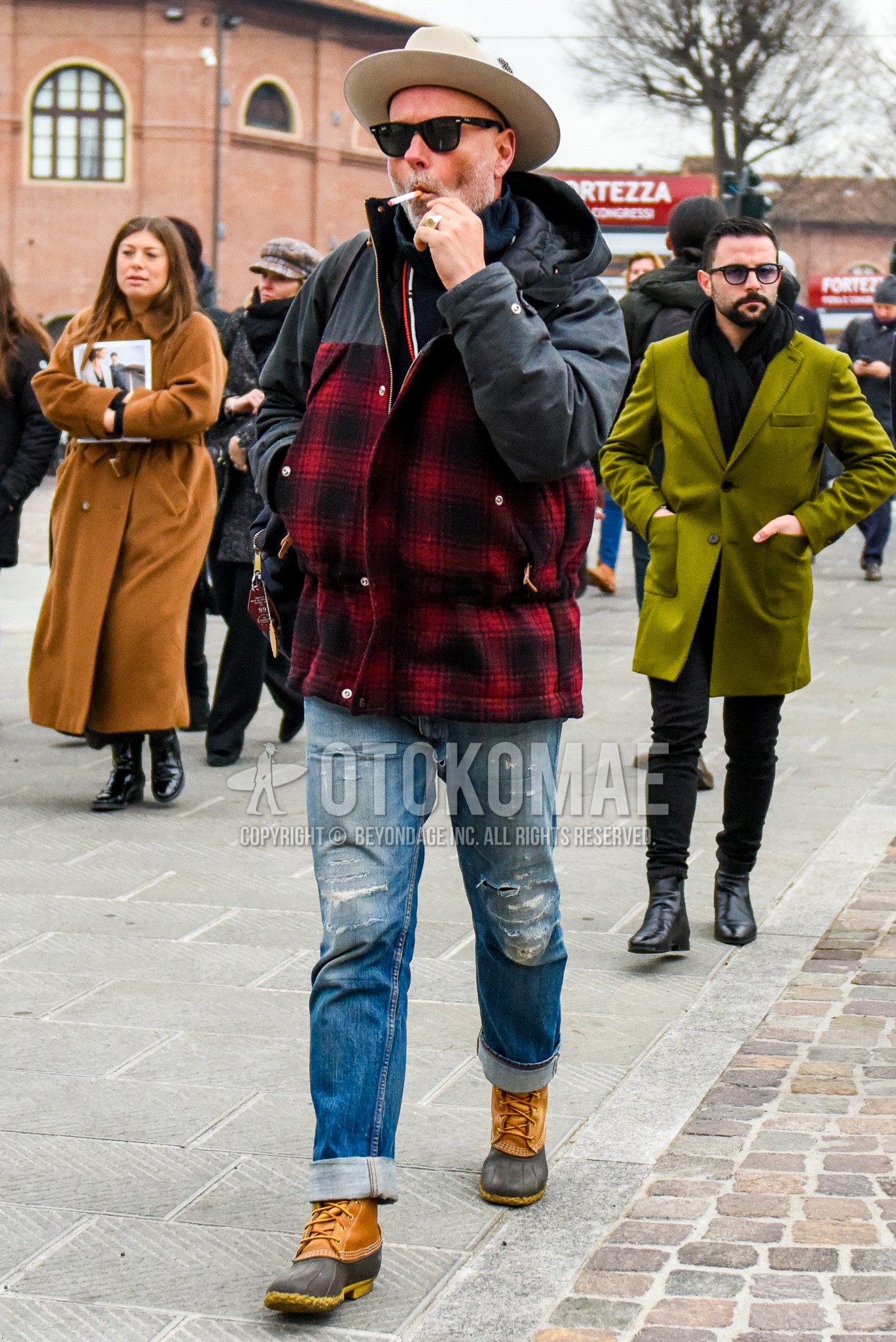 Men's winter outfit with brown plain hat, plain glasses, red check hooded coat, blue plain damaged jeans, brown  boots.