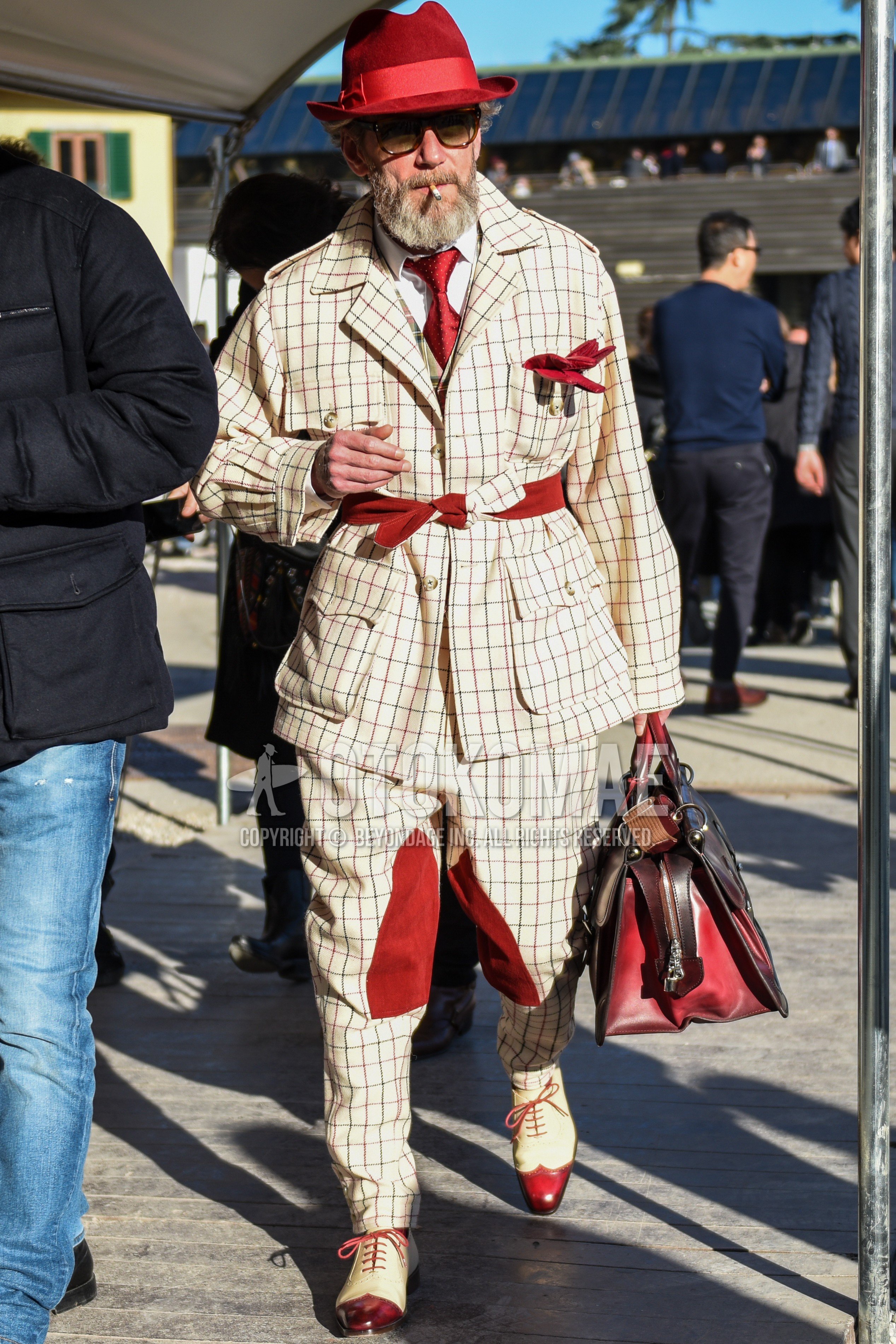 Men's autumn winter outfit with red plain hat, brown tortoiseshell sunglasses, white plain shirt, white red brogue shoes leather shoes, brown plain briefcase/handbag, white suit casual setup, red necktie necktie.