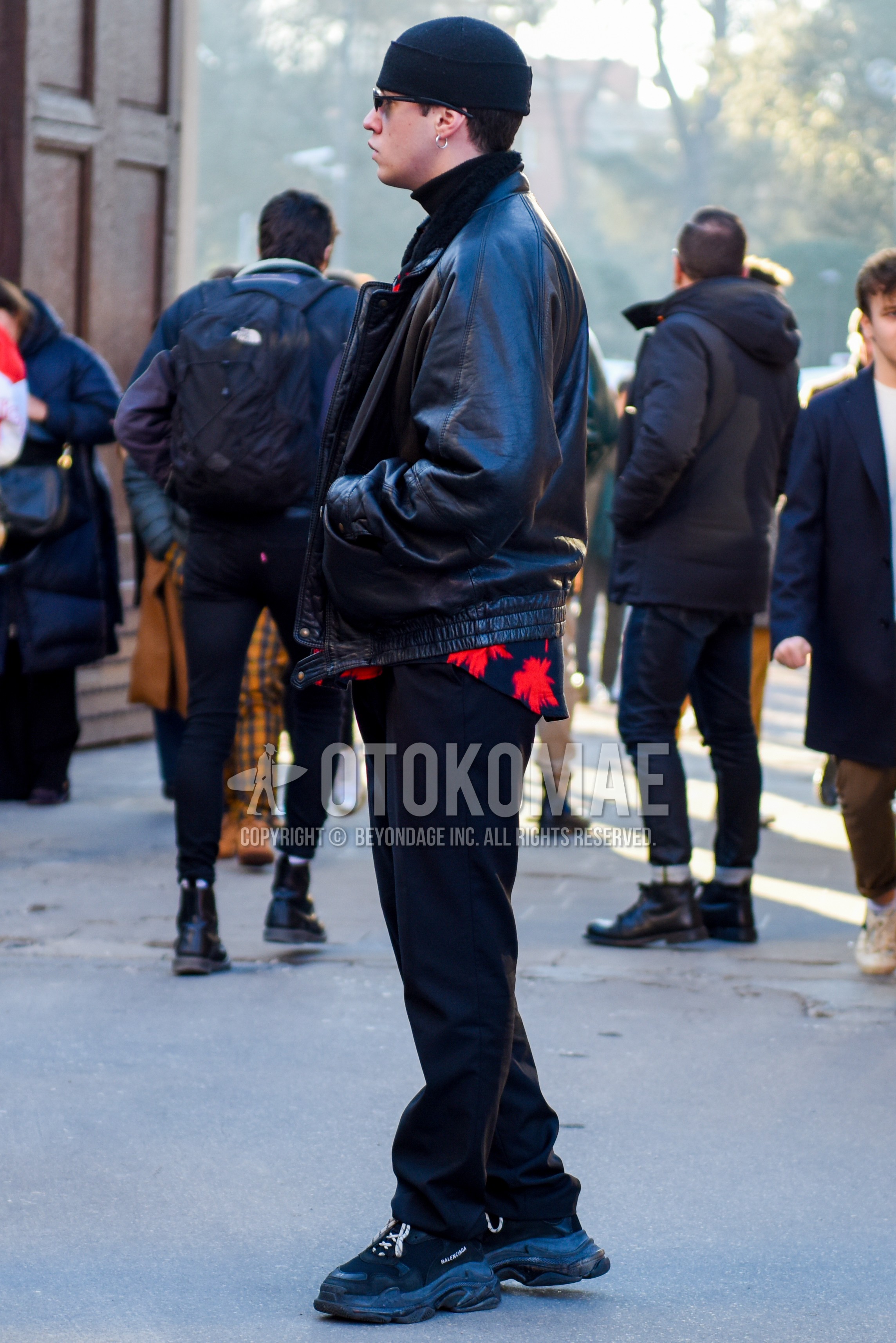 Men's autumn winter outfit with black plain knit cap, black plain sunglasses, black plain leather jacket, black plain turtleneck knit, black plain slacks, black low-cut sneakers.