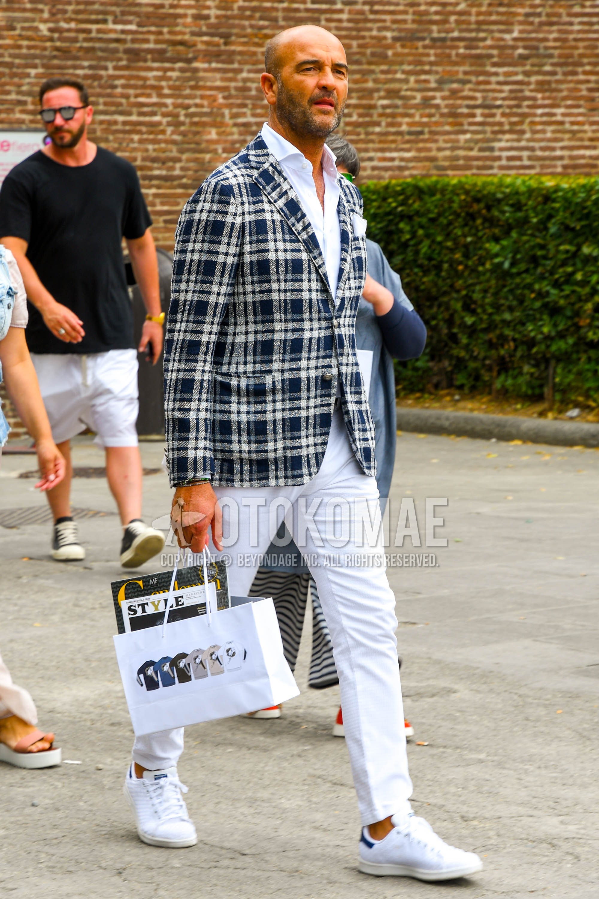 Men's spring summer autumn outfit with white navy check tailored jacket, white plain cotton pants, white low-cut sneakers.