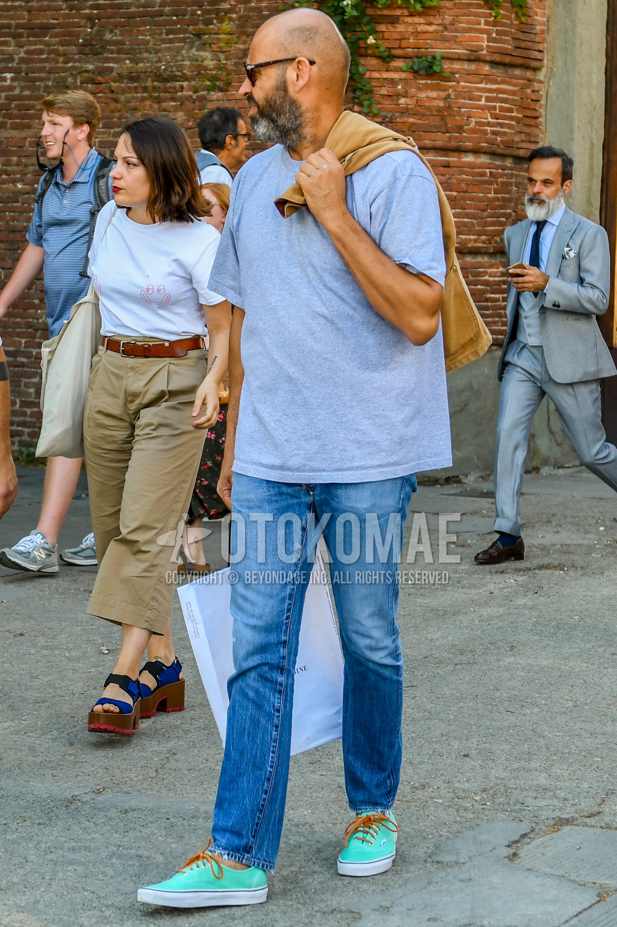 Men's summer outfit with tortoiseshell sunglasses, gray plain t-shirt, blue plain denim/jeans, light blue low-cut sneakers.