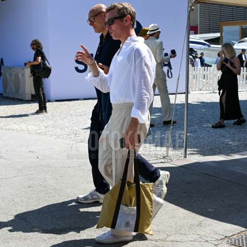 黒無地のサングラス、白無地のシャツ、白無地のタンクトップ、白無地のイージーパンツ、白無地のスラックス、白ローカットのスニーカー、イエローバッグのトートバッグを合わせた夏春のメンズコーデ・着こなし。