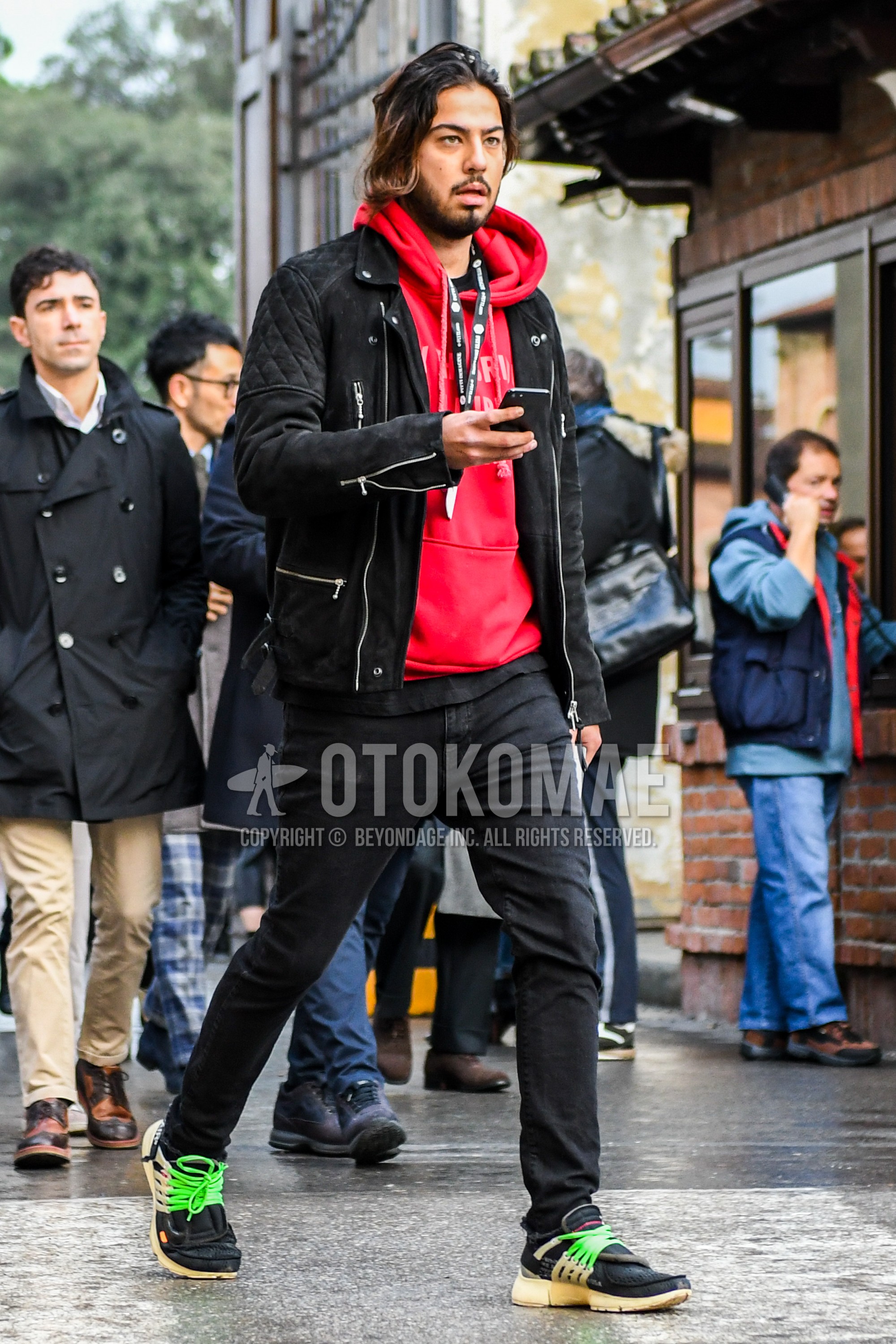 Men's winter outfit with black plain riders jacket, red plain hoodie, black plain denim/jeans, black green sneakers.