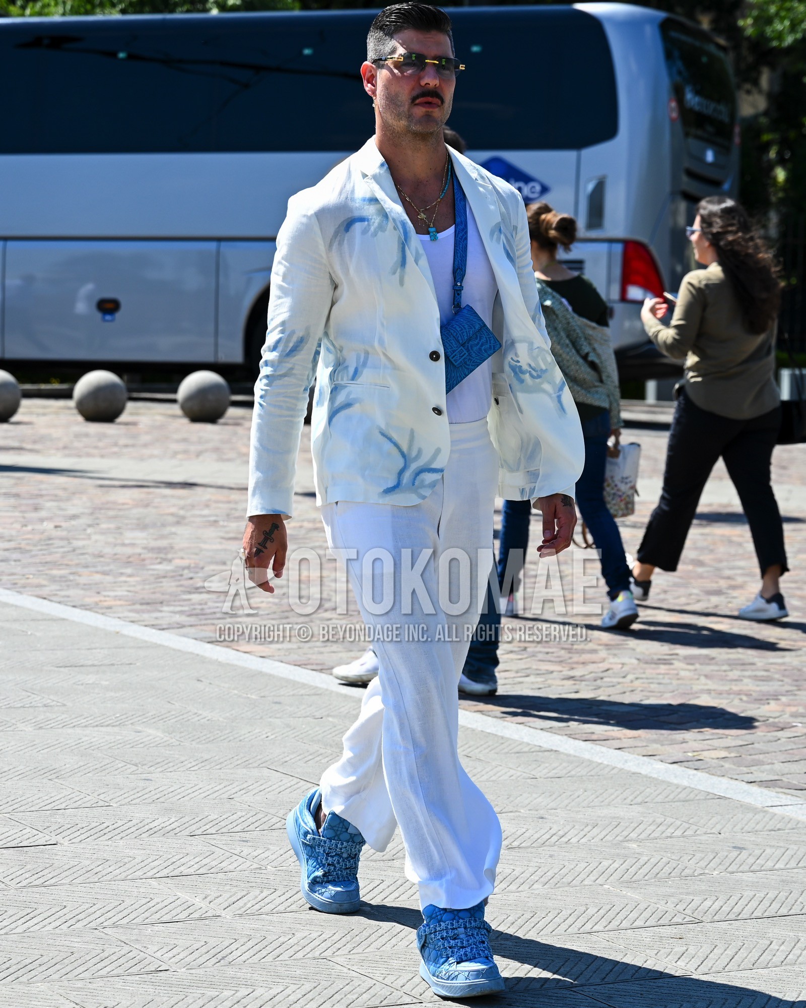 Men's spring summer autumn outfit with black plain sunglasses, white whole pattern tailored jacket, white plain tank top, white plain slacks, light blue high-cut sneakers, light blue plain body bag.