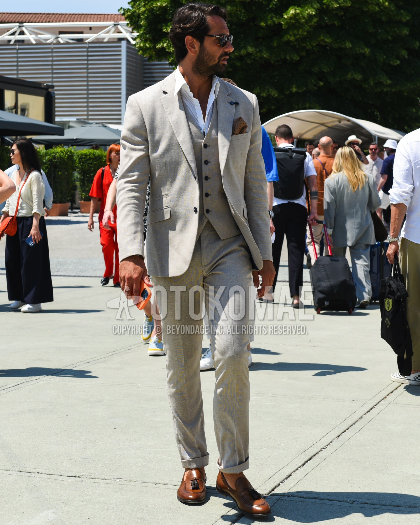 Men's spring summer outfit with black plain sunglasses, white plain shirt, brown tassel loafers leather shoes, gray plain three-piece suit.