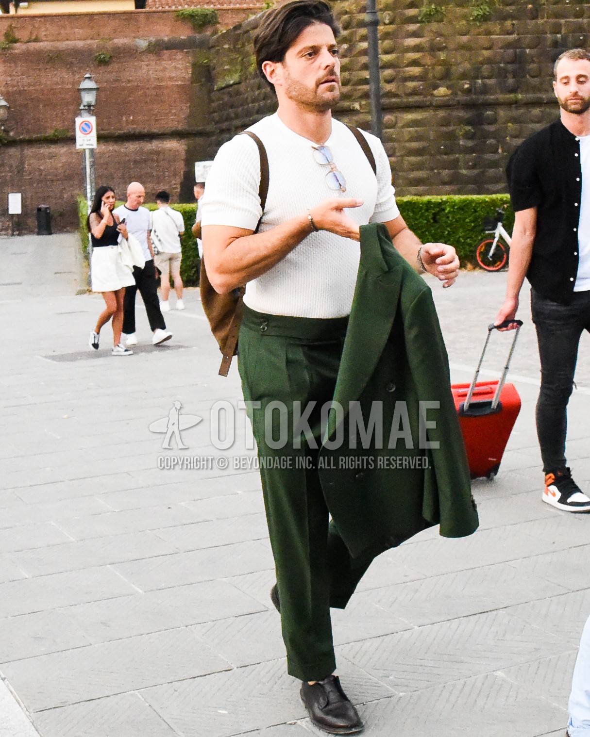 Men's spring summer outfit with white plain t-shirt, brown plain toe leather shoes, brown plain backpack, green plain suit.
