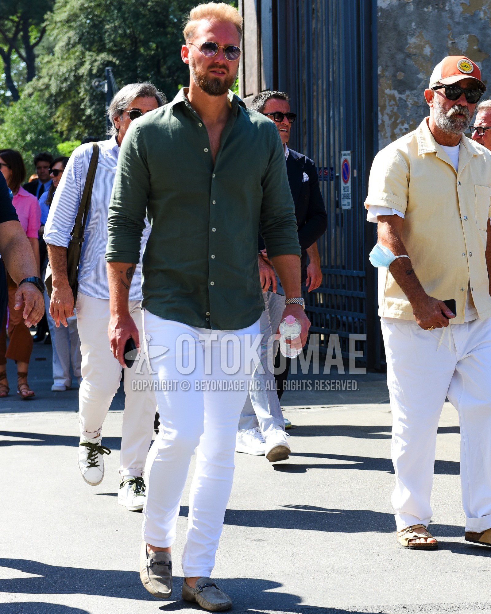 Men's spring summer outfit with gold plain sunglasses, green plain shirt, white plain cotton pants, gray bit loafers leather shoes.