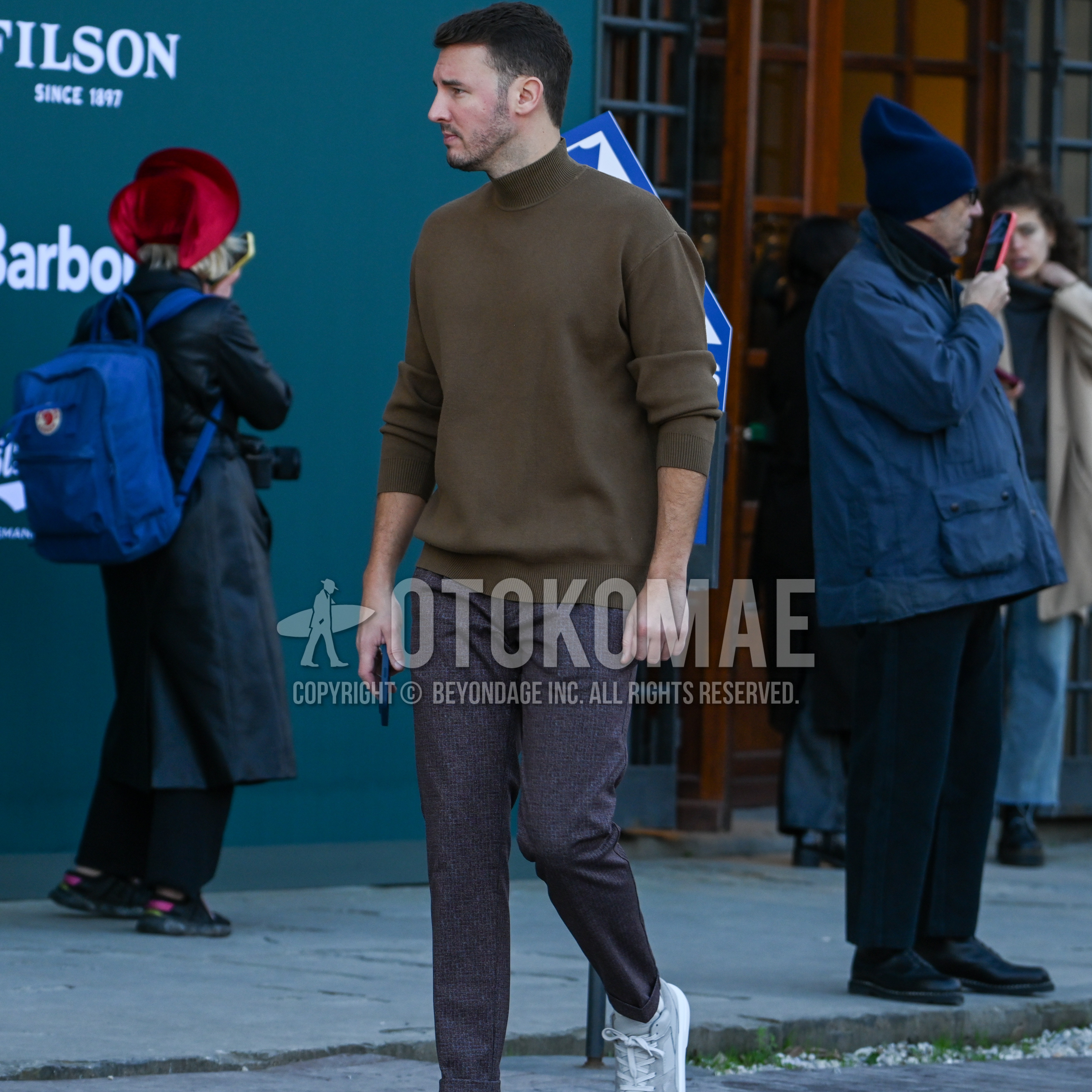 Men's autumn winter outfit with brown plain turtleneck knit, dark gray check ankle pants, gray low-cut sneakers.