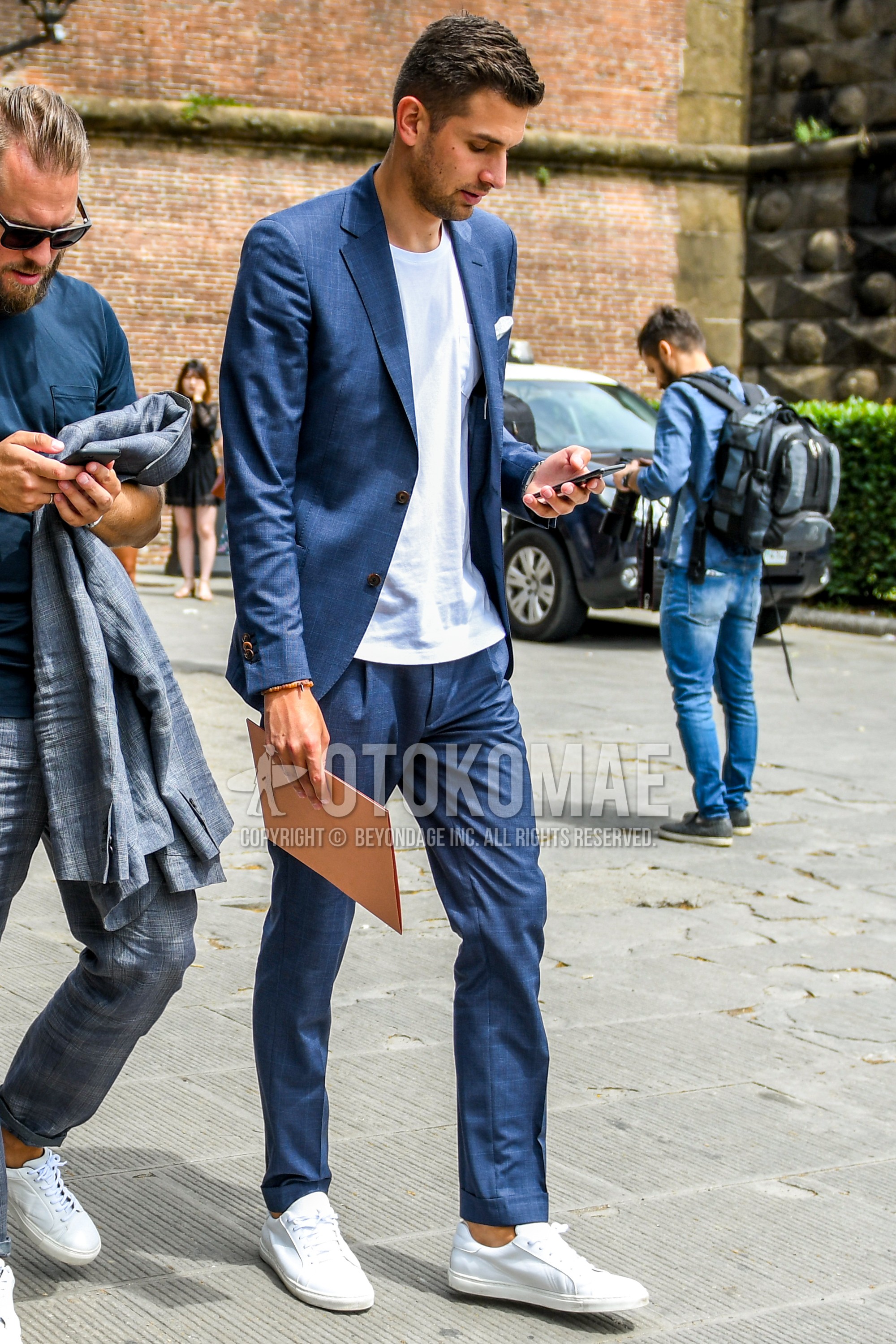 Men's spring summer outfit with white plain t-shirt, white low-cut sneakers, navy check suit.
