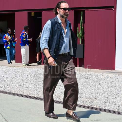 黒無地のサングラス、ブルー無地のカジュアルベスト、ブルー無地のデニム/シャンブレーシャツ、ブラウン無地のメッシュベルト、ブラウン無地のデニム/ジーンズ、ブラウン無地のアンクルパンツ、ブラウンローファーの革靴を合わせた夏春のメンズコーデ・着こなし。