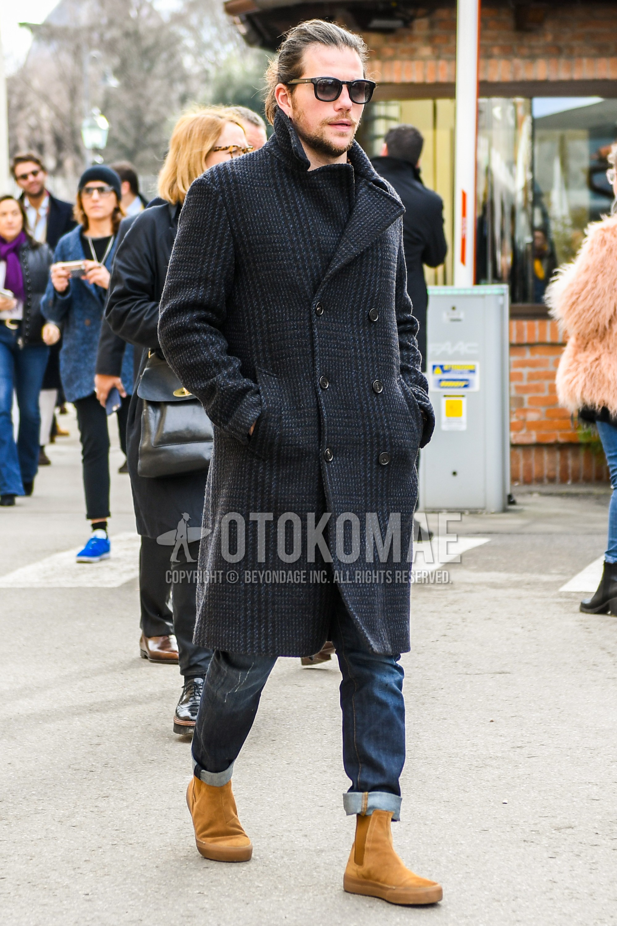 Men's winter outfit with black plain sunglasses, dark gray check ulster coat, navy plain denim/jeans, beige side-gore boots.