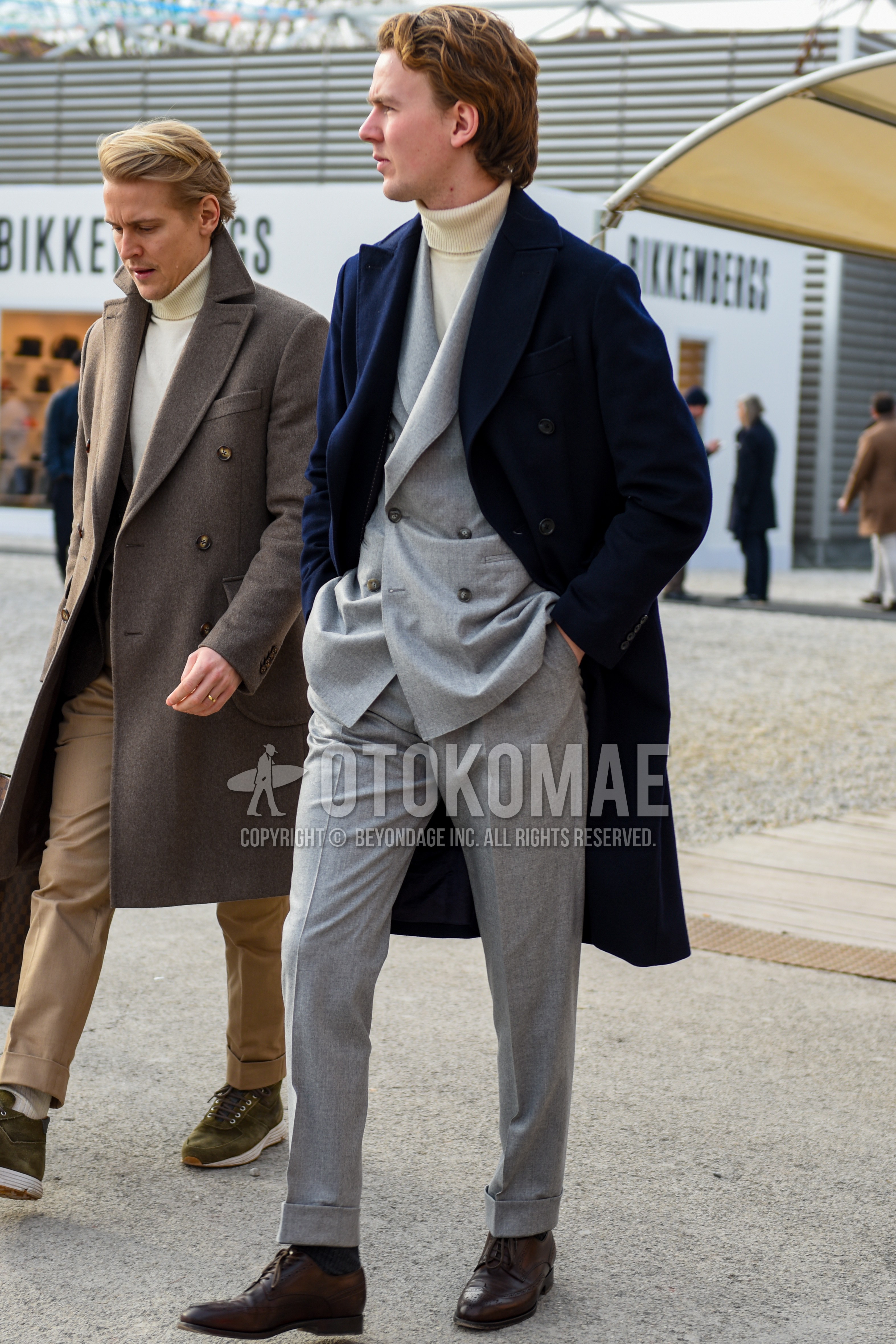 Men's autumn winter outfit with navy plain chester coat, white plain turtleneck knit, navy plain socks, brown wing-tip shoes leather shoes, gray plain suit.