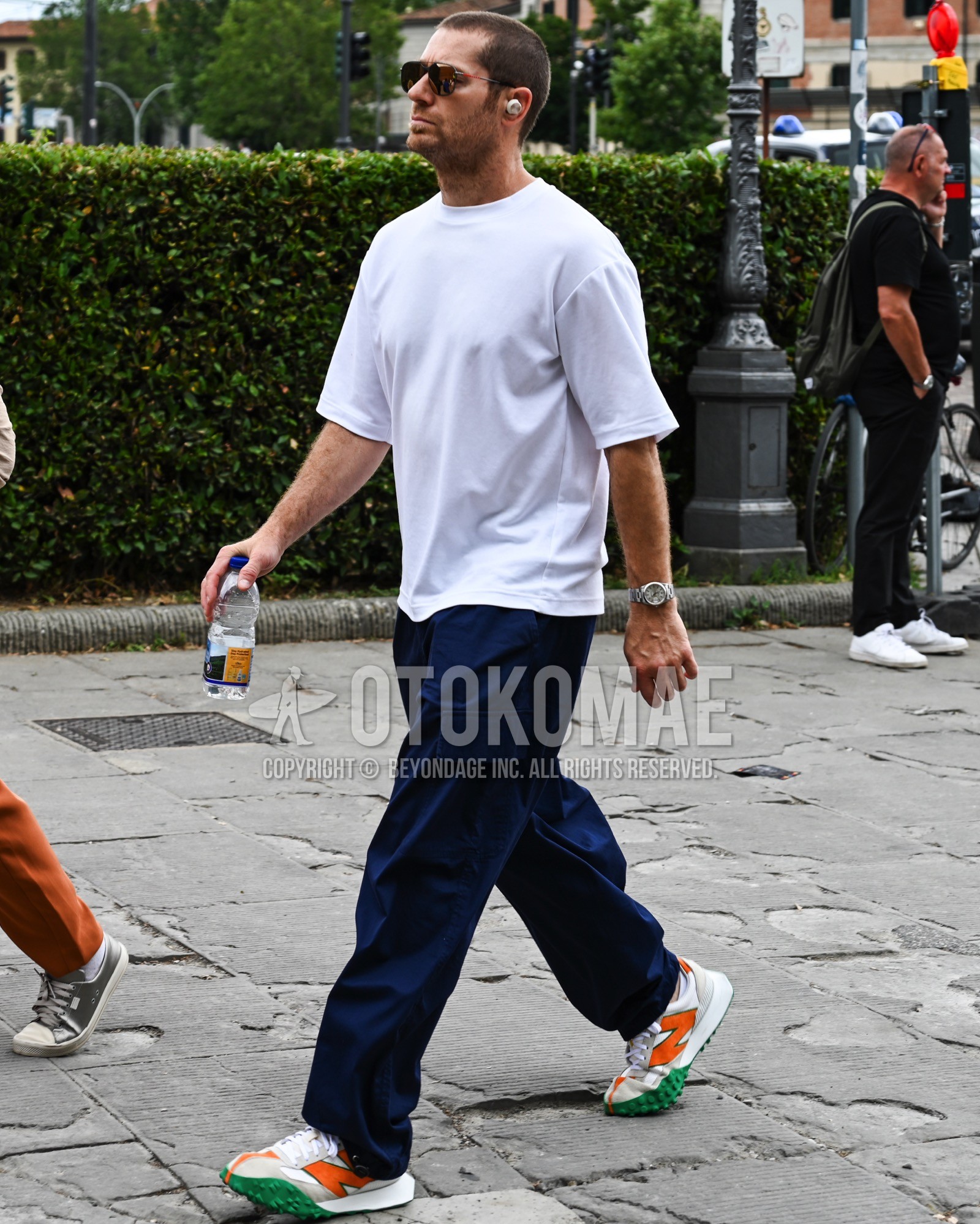 Men's spring summer outfit with white plain sunglasses, navy plain wide pants, white low-cut sneakers.
