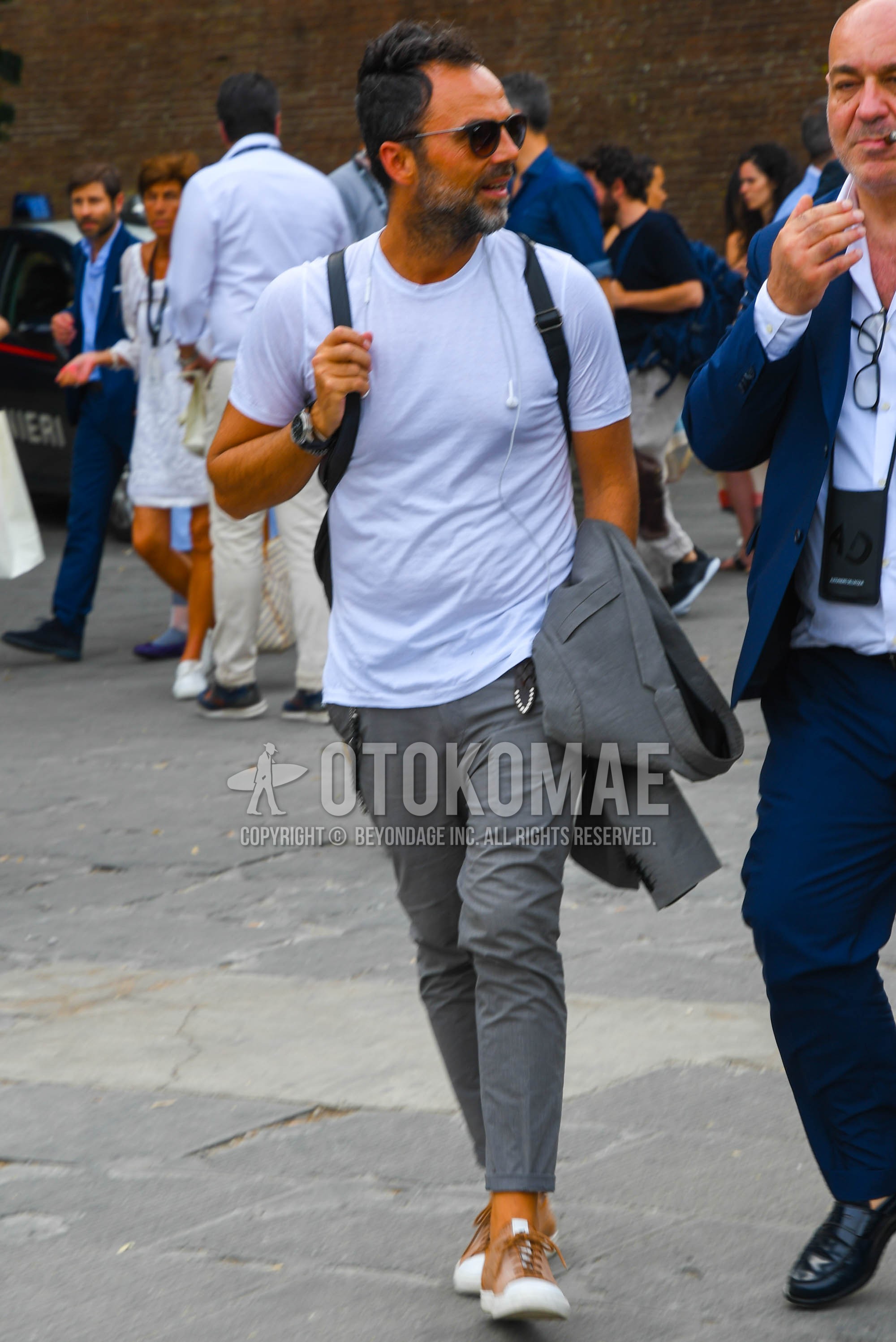 Men's summer outfit with plain sunglasses, white plain t-shirt, gray plain slacks, brown low-cut sneakers.