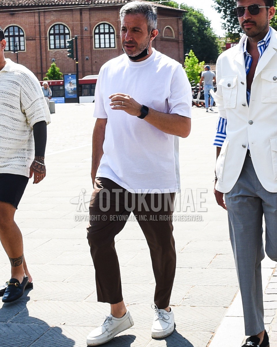 Men's spring summer outfit with white plain t-shirt, brown plain slacks, white moccasins/deck shoes leather shoes.