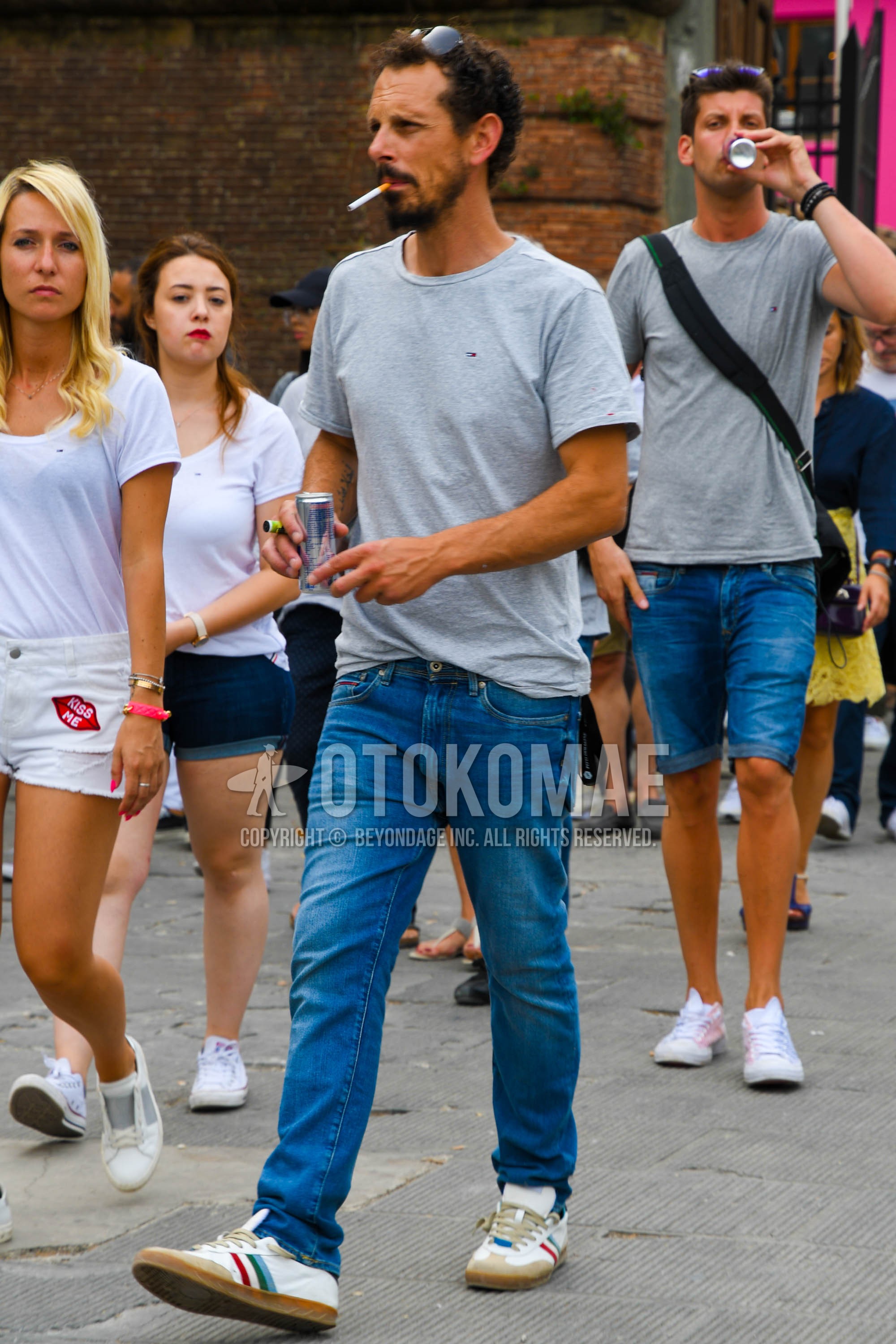 Men's spring summer outfit with plain sunglasses, gray plain t-shirt, blue plain denim/jeans, white low-cut sneakers.