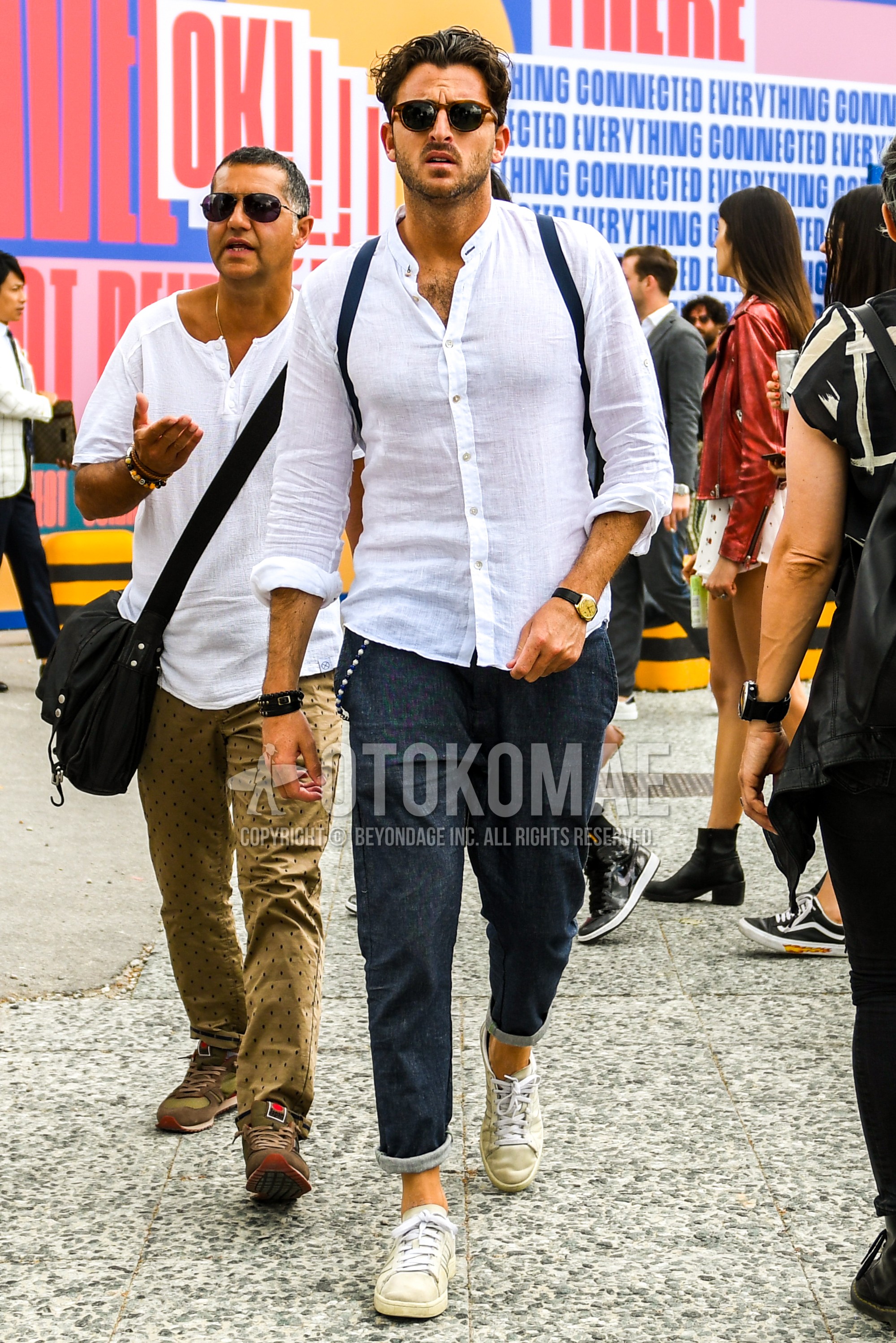 Men's summer outfit with tortoiseshell sunglasses, white plain shirt, navy plain denim/jeans, white low-cut sneakers.