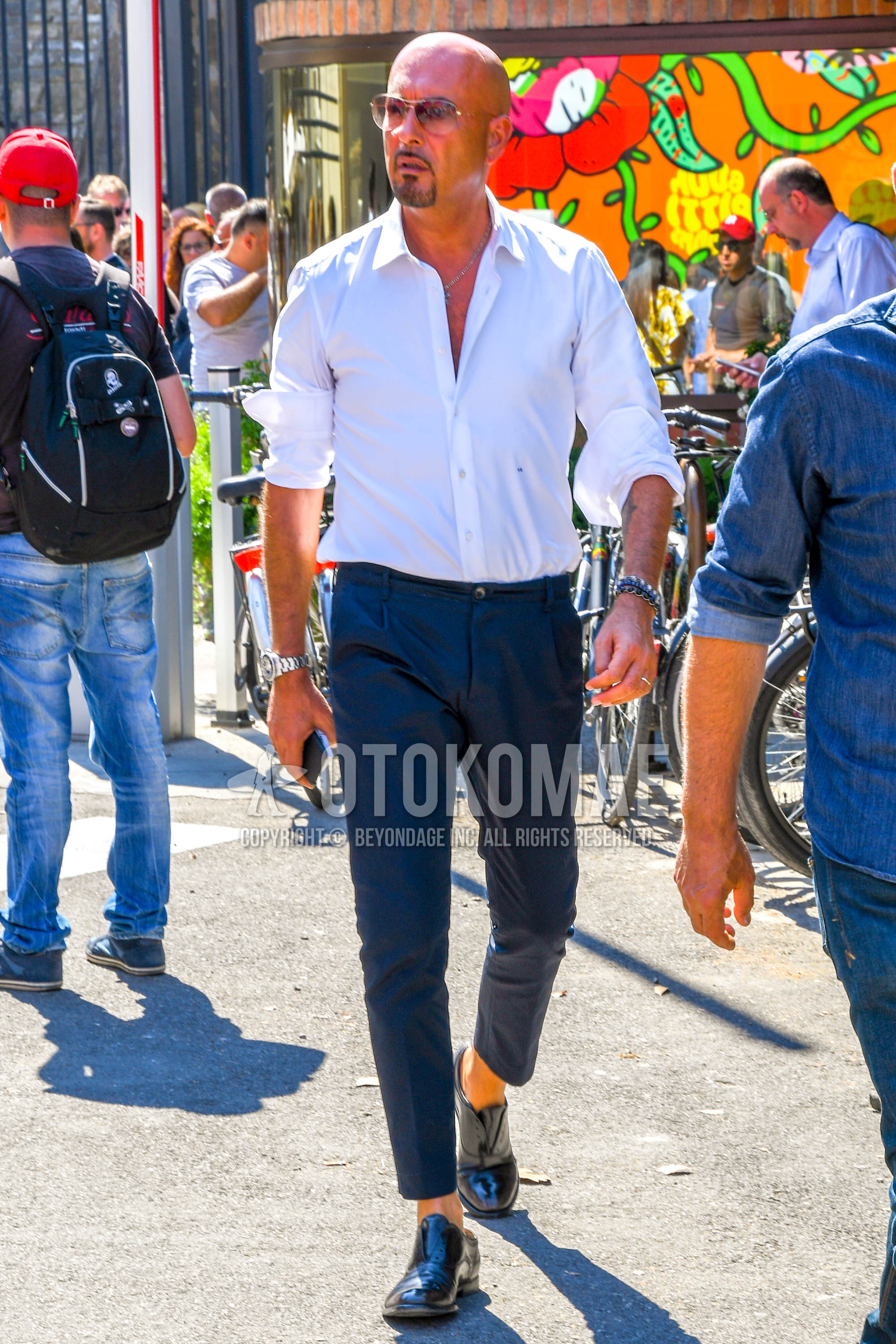 Men's spring summer outfit with white plain shirt, gray plain slacks, plain cropped pants, black  leather shoes.