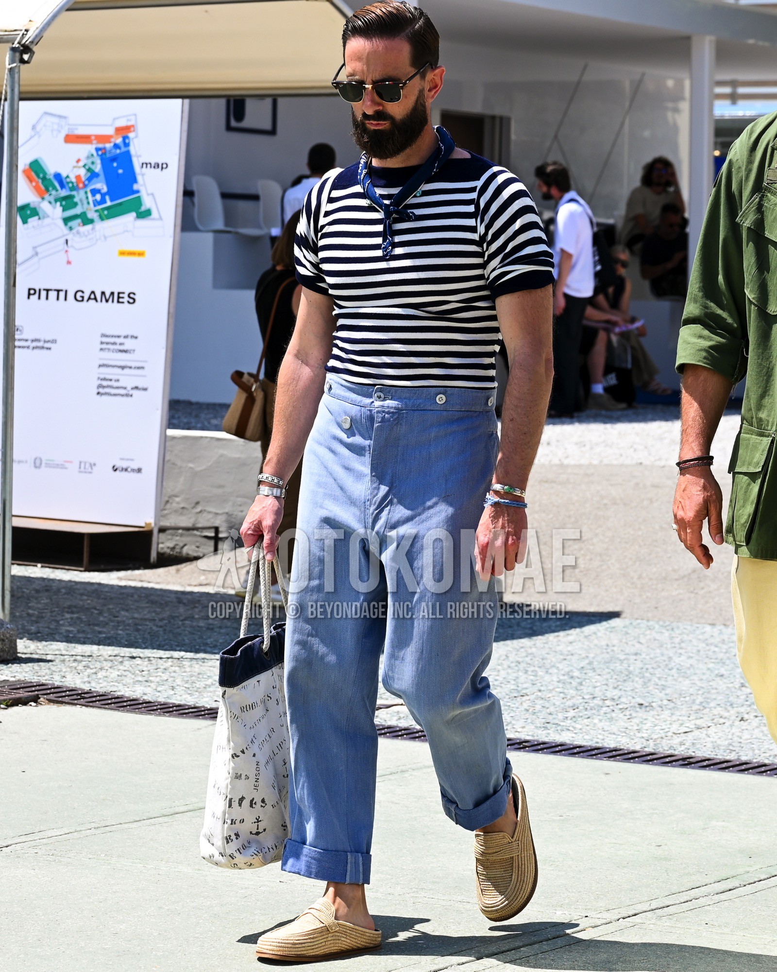 Men's spring summer outfit with black plain sunglasses, navy whole pattern bandana/neckerchief, white black horizontal stripes t-shirt, light blue plain bottoms, beige coin loafers leather shoes, sandals, white whole pattern tote bag.