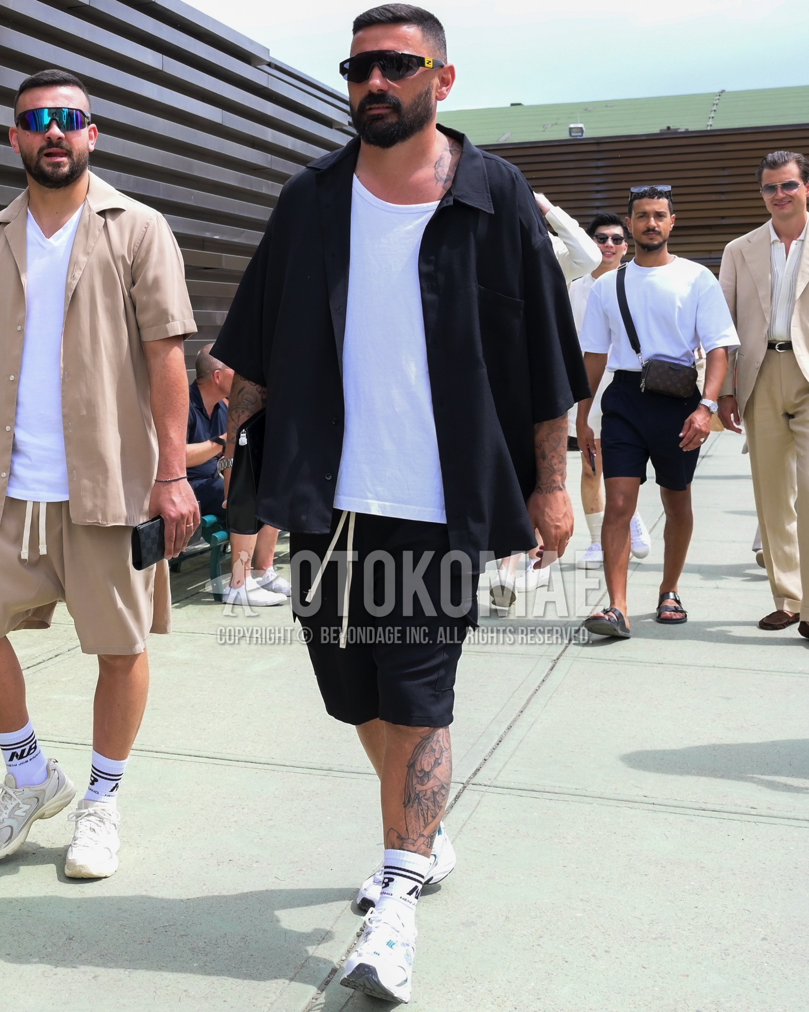 Men's spring summer outfit with black plain sunglasses, black plain shirt, white plain t-shirt, black plain short pants, white one point socks, white low-cut sneakers.