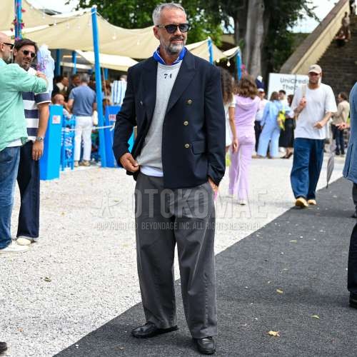 黒無地のサングラス、ブルーストールのスカーフ、黒無地のテーラードジャケット、白ワンポイントのTシャツ、グレー無地のデニム/ジーンズ、黒ローファーの革靴を合わせた春夏のメンズコーデ・着こなし。