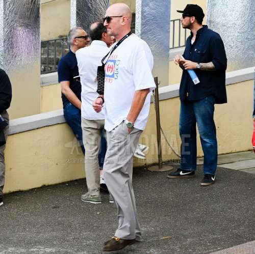 ブラウンべっ甲のサングラス、グッチの白グラフィックのTシャツ、グレー無地のスラックス、グッチのブラウンビットローファーの革靴、黒バッグのクラッチバッグ/セカンドバッグ/巾着を合わせた春夏のメンズコーデ・着こなし。