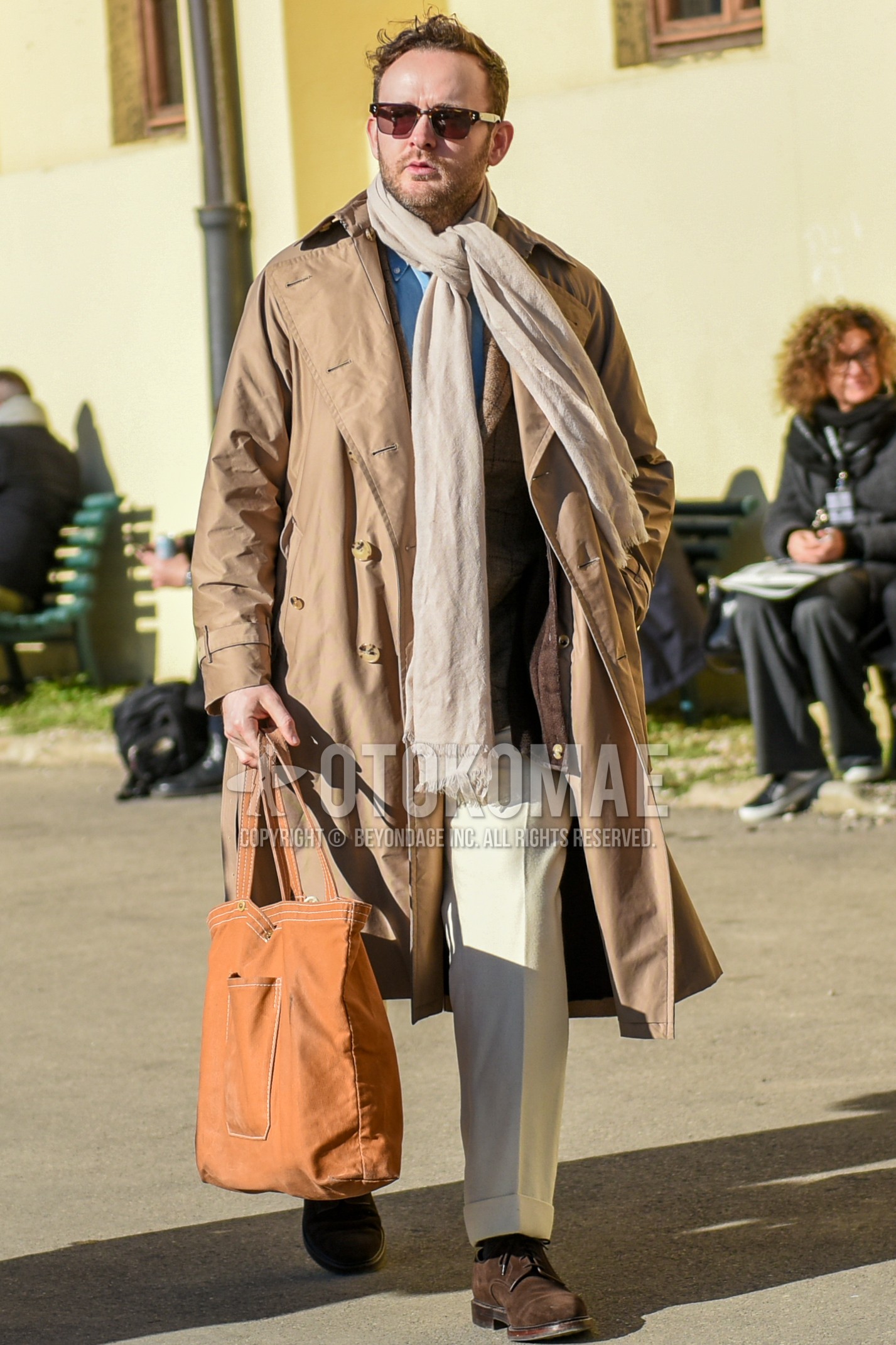 Men's autumn winter outfit with brown tortoiseshell sunglasses, beige plain scarf, beige plain trench coat, beige plain slacks, brown  boots, brown plain briefcase/handbag.