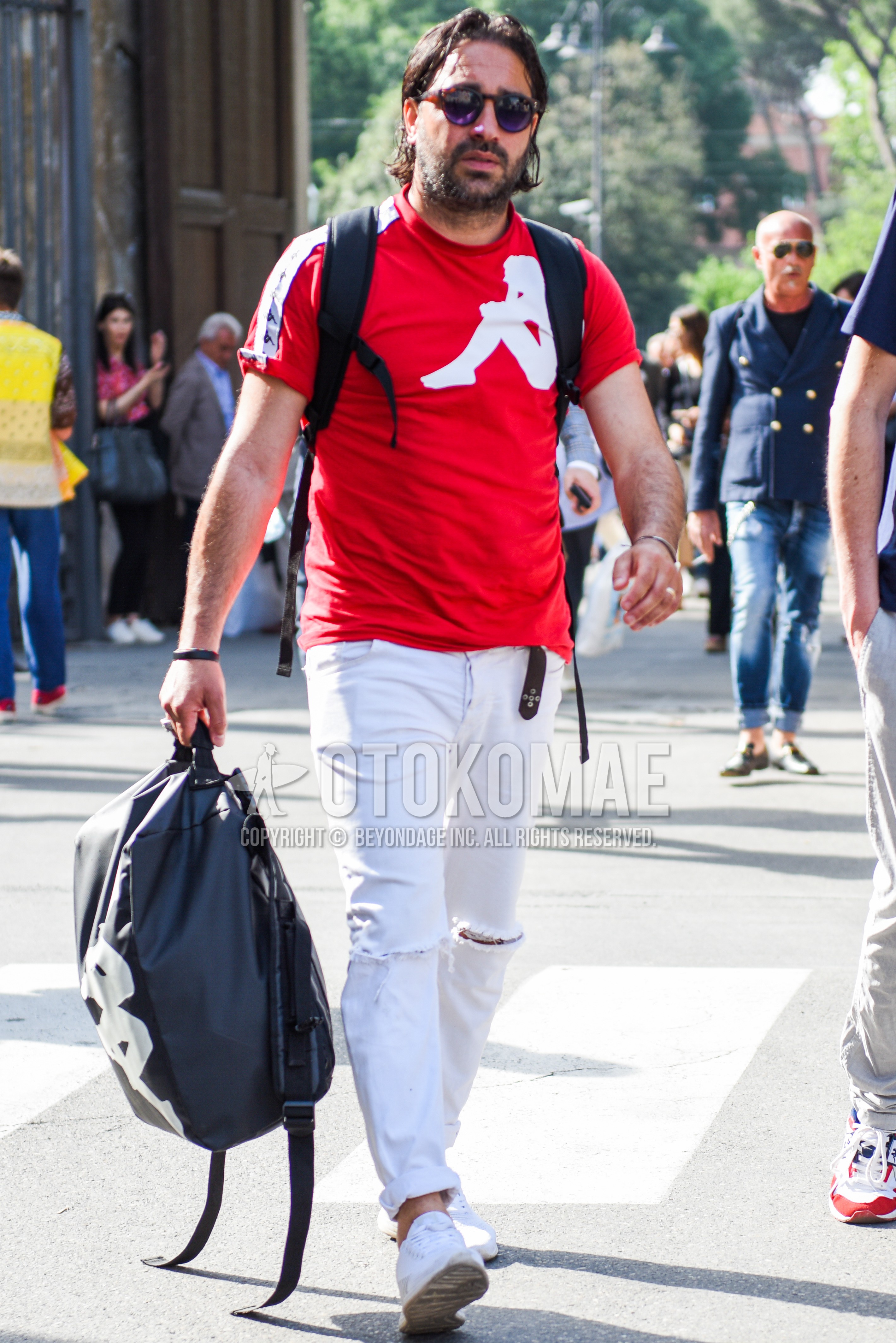 Men's summer outfit with black plain sunglasses, red plain t-shirt, white plain damaged jeans, white low-cut sneakers, black deca logo backpack.