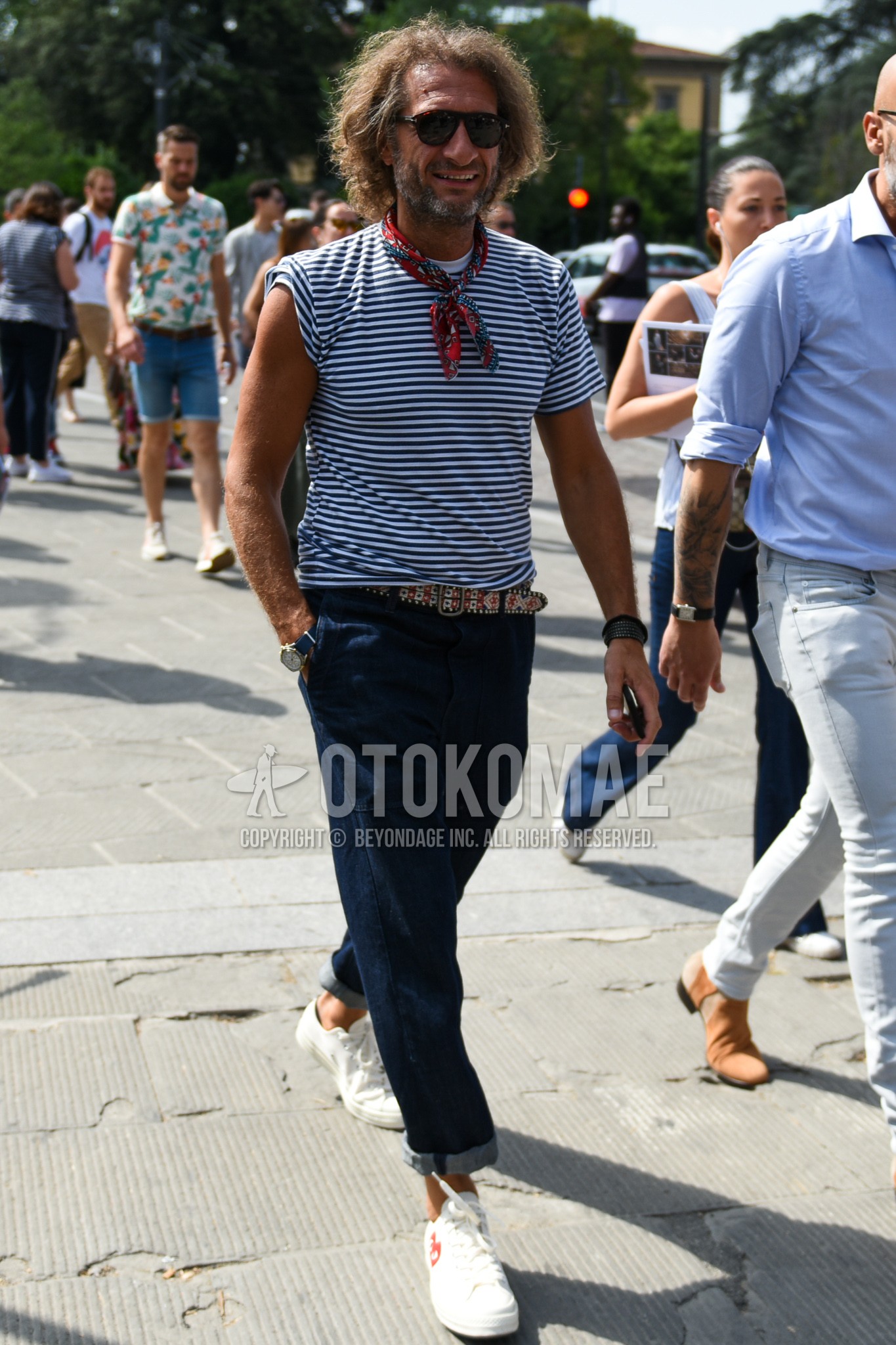Men's summer outfit with brown tortoiseshell sunglasses, red scarf bandana/neckerchief, white navy horizontal stripes t-shirt, red belt leather belt, navy plain denim/jeans, white low-cut sneakers.