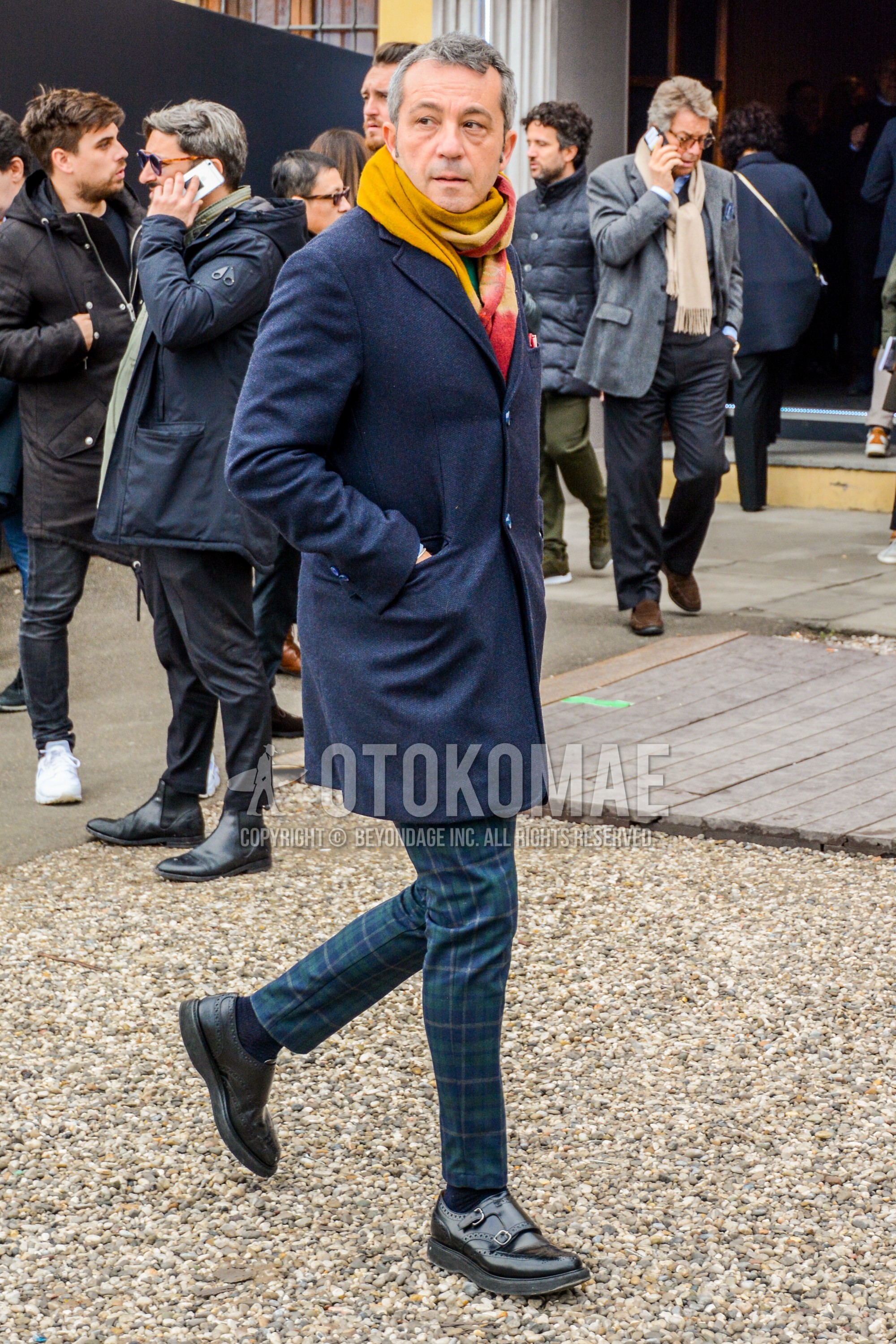 Men's autumn winter outfit with multi-color scarf scarf, gray plain chester coat, olive green navy check slacks, navy plain socks, black monk shoes leather shoes.