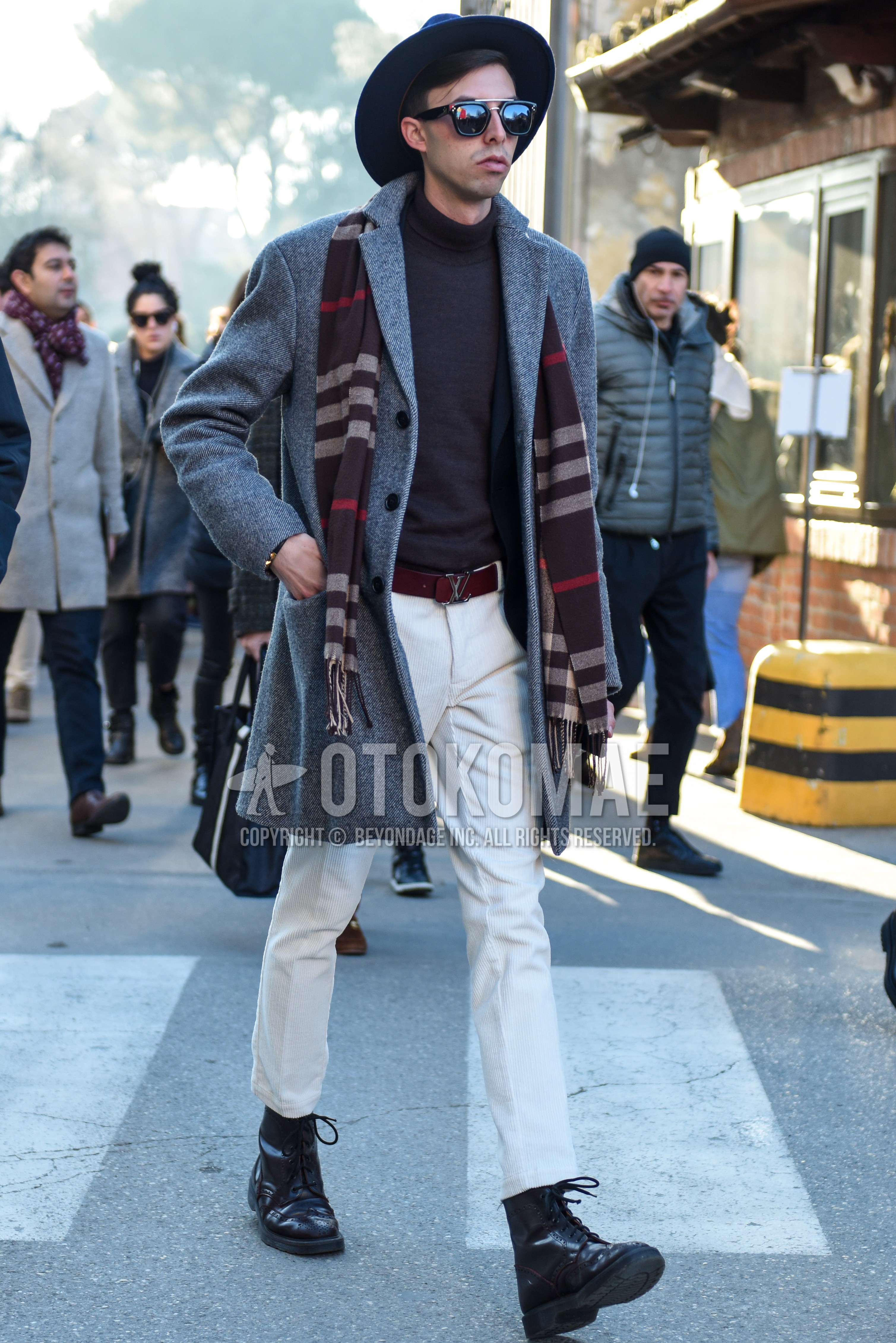 Men's autumn winter outfit with black plain hat, black plain sunglasses, gray horizontal stripes scarf, gray plain chester coat, black plain turtleneck knit, brown plain leather belt, white plain slacks, black  boots.