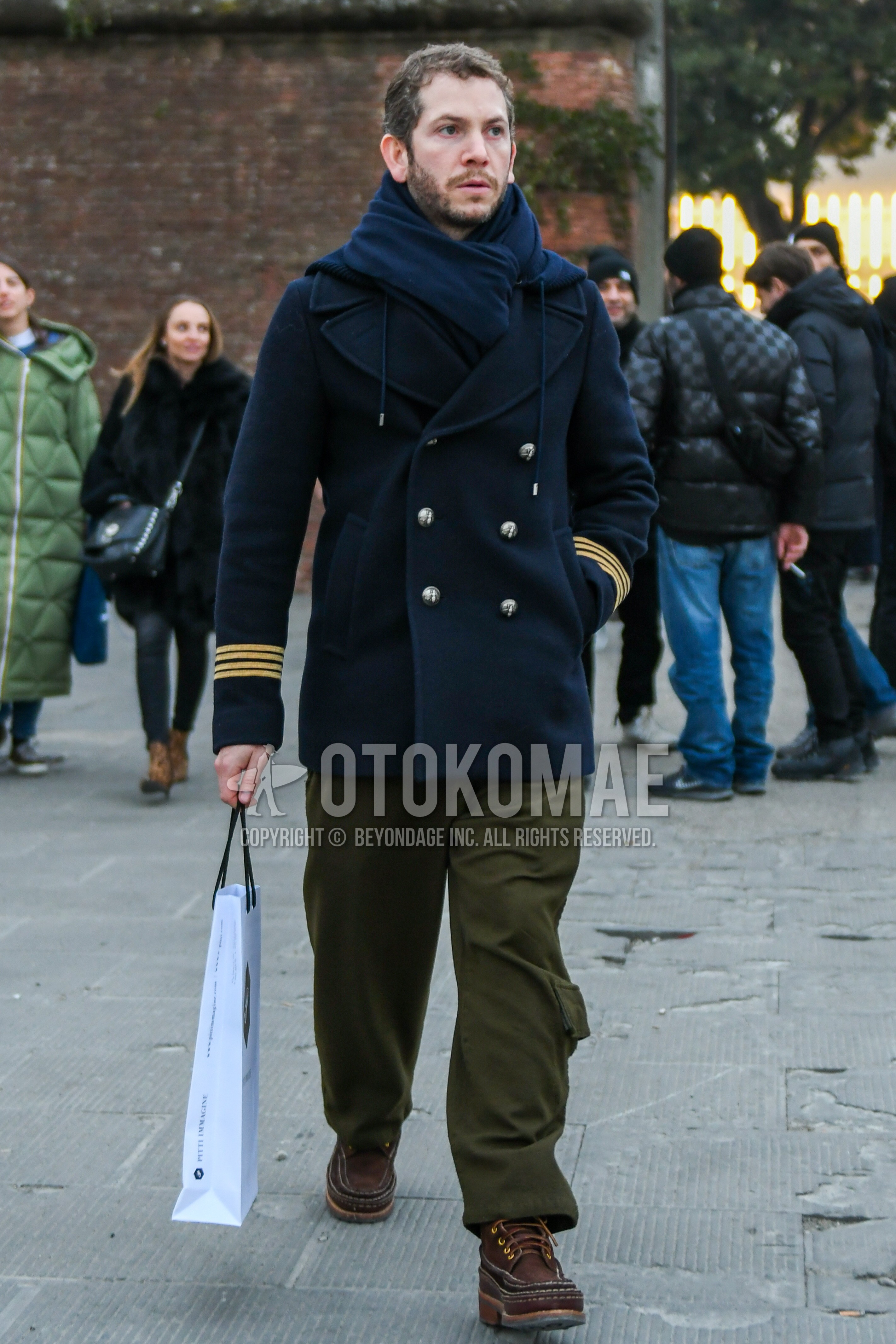 Men's winter outfit with navy plain scarf, navy plain p coat, olive green plain cargo pants, brown  boots.