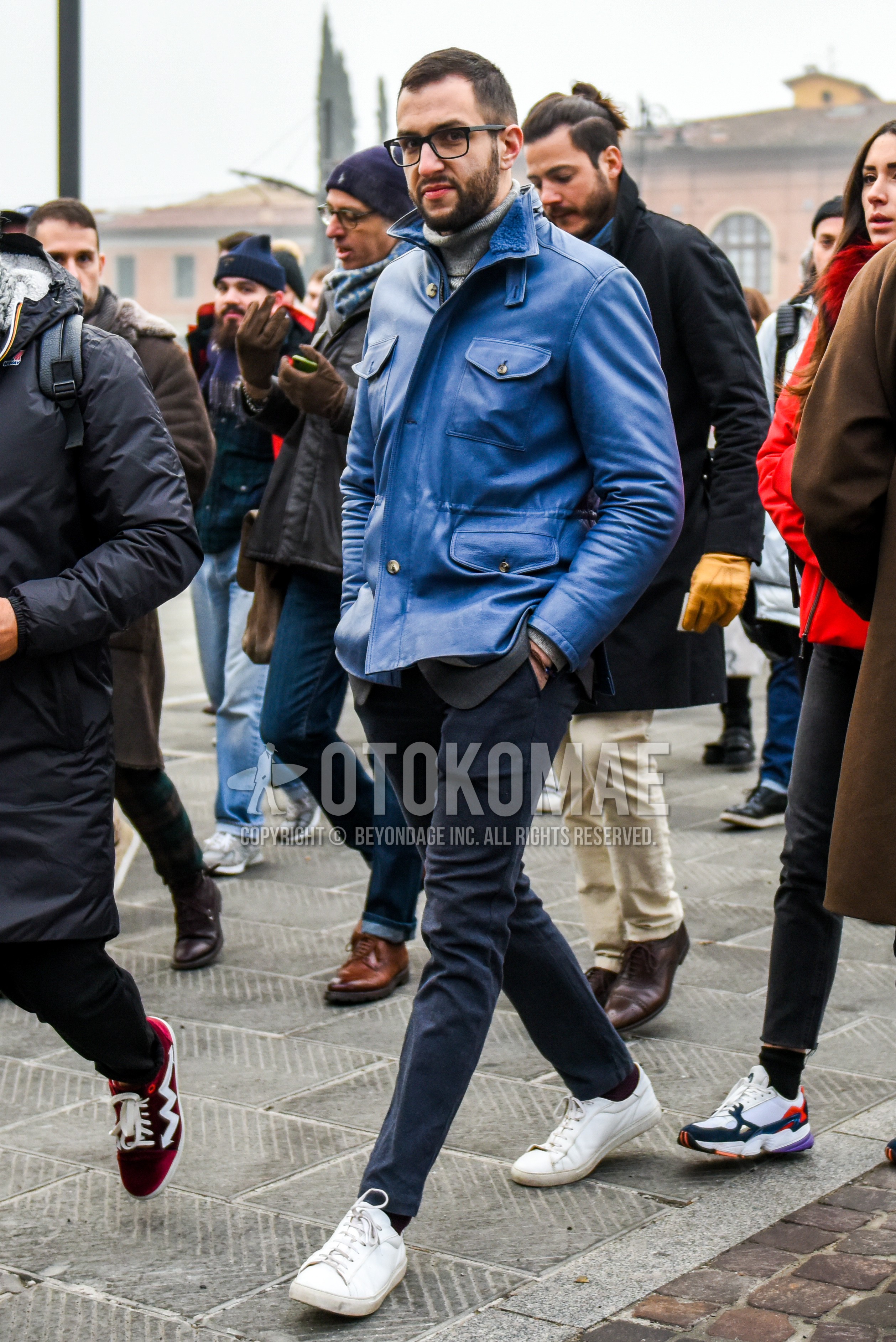 Men's winter outfit with plain glasses, blue plain leather jacket, gray plain turtleneck knit, dark gray plain skinny pants, white low-cut sneakers.