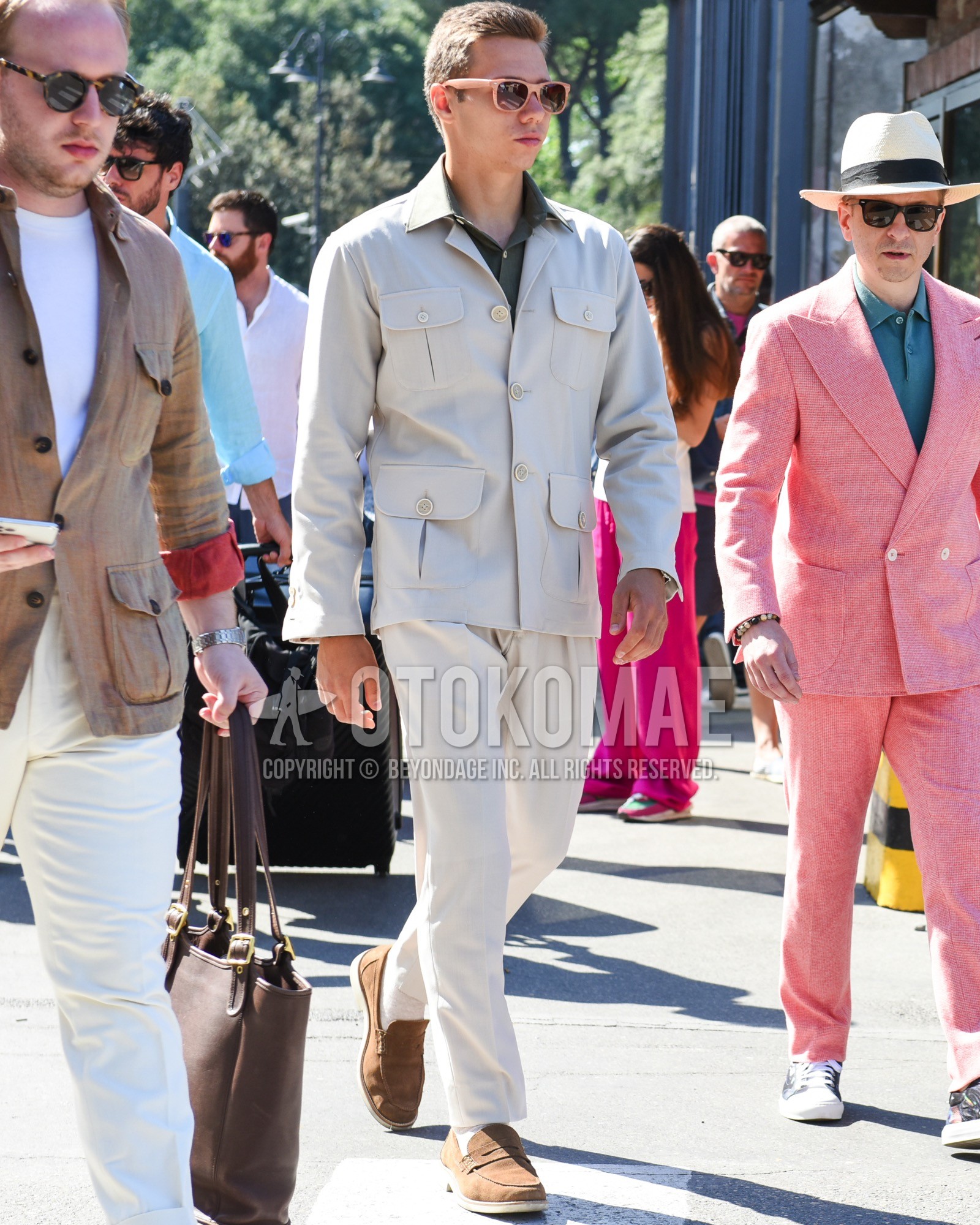 Men's spring summer outfit with pink plain sunglasses, beige plain field jacket/hunting jacket, olive green plain shirt, beige plain slacks, brown coin loafers leather shoes, brown suede shoes leather shoes, brown slip-on sneakers.