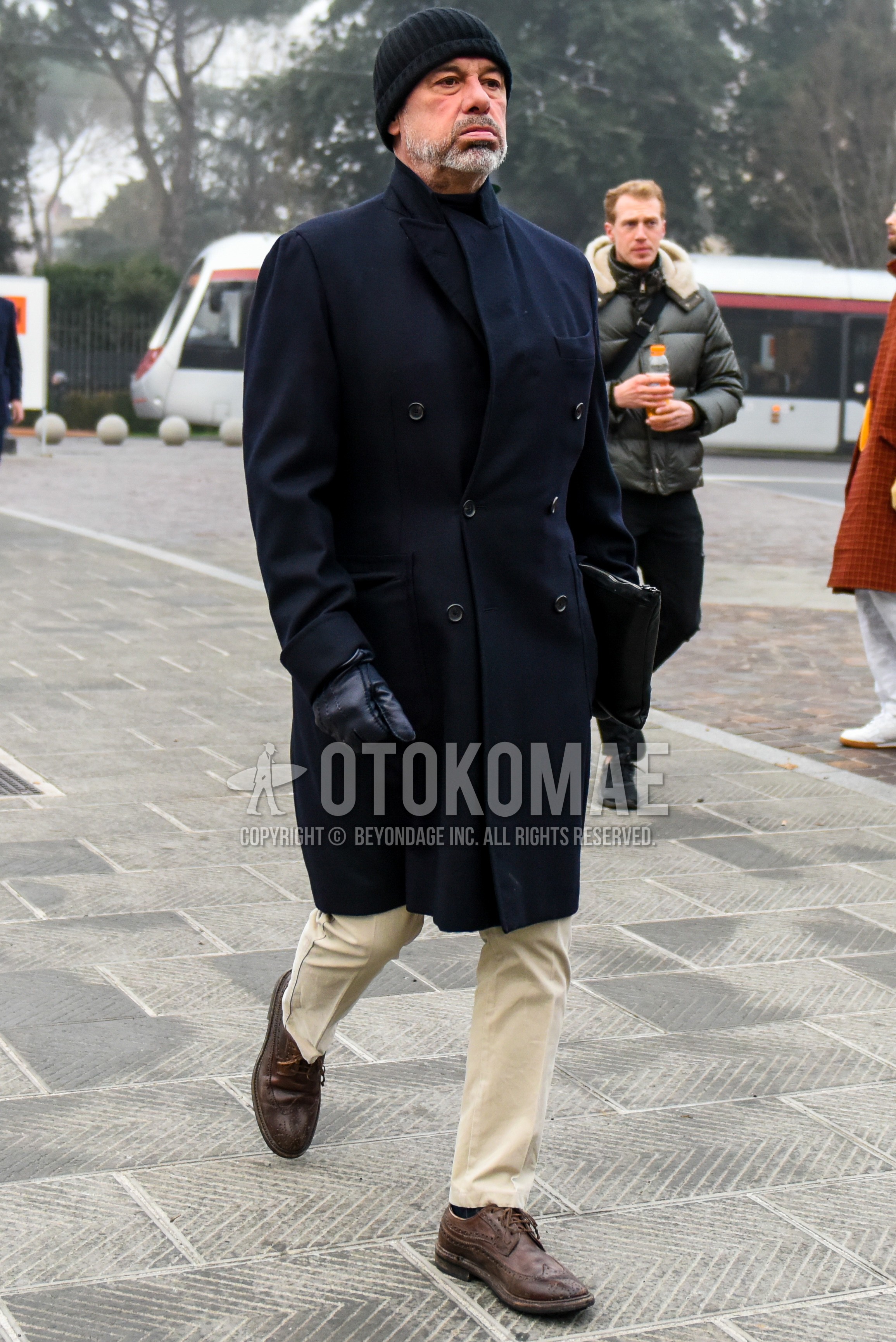 Men's autumn winter outfit with black plain knit cap, navy plain chester coat, beige plain chinos, brown wing-tip shoes leather shoes.