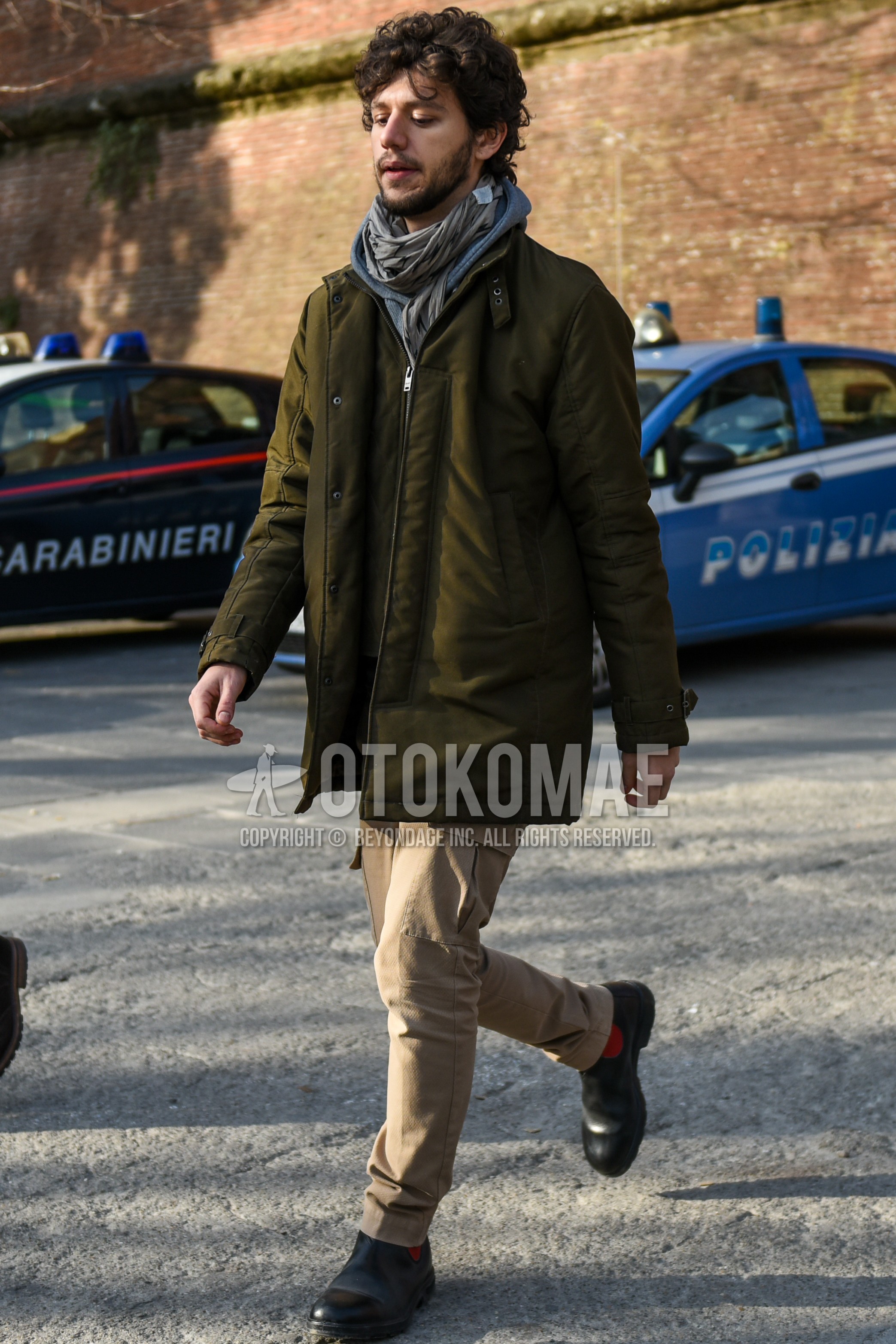 Men's winter outfit with gray plain scarf, olive green plain stenkarrer coat, beige plain cargo pants, brown side-gore boots.