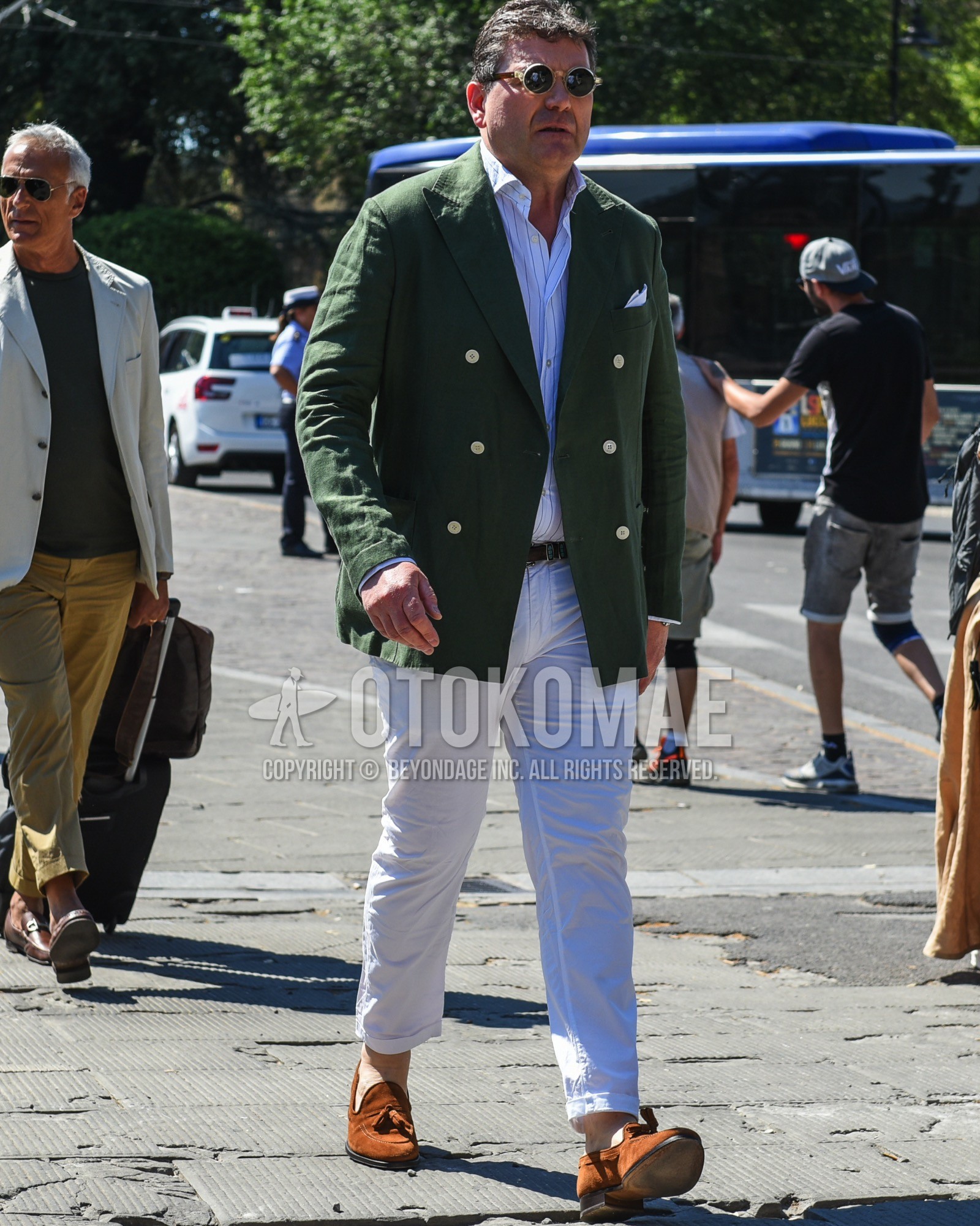 Men's spring summer outfit with brown clear plain sunglasses, olive green plain tailored jacket, white stripes shirt, brown plain leather belt, white plain cotton pants, brown tassel loafers leather shoes, brown suede shoes leather shoes.