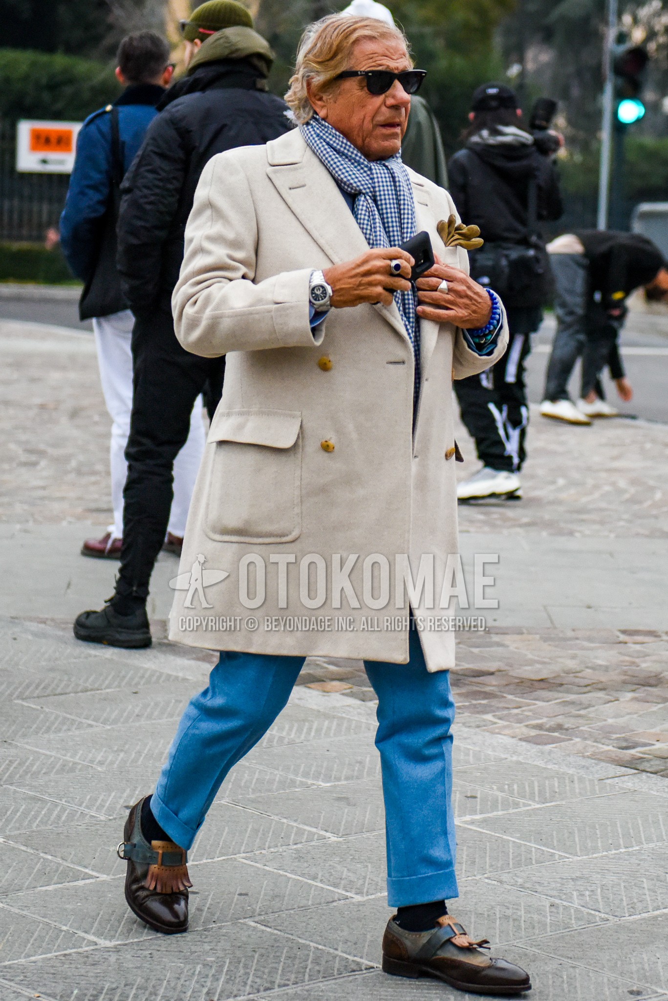 Men's winter outfit with plain sunglasses, blue check scarf, white plain tailored jacket, blue plain slacks, navy plain socks, brown wing-tip shoes leather shoes.