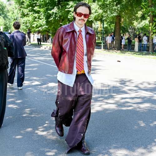 レッド無地のサングラス、レッド無地のレザージャケット(ライダース以外)、白無地のシャツ、レッド無地のボトムス、レッドのブーツ、レッド総柄のネクタイを合わせた春夏のメンズコーデ・着こなし。