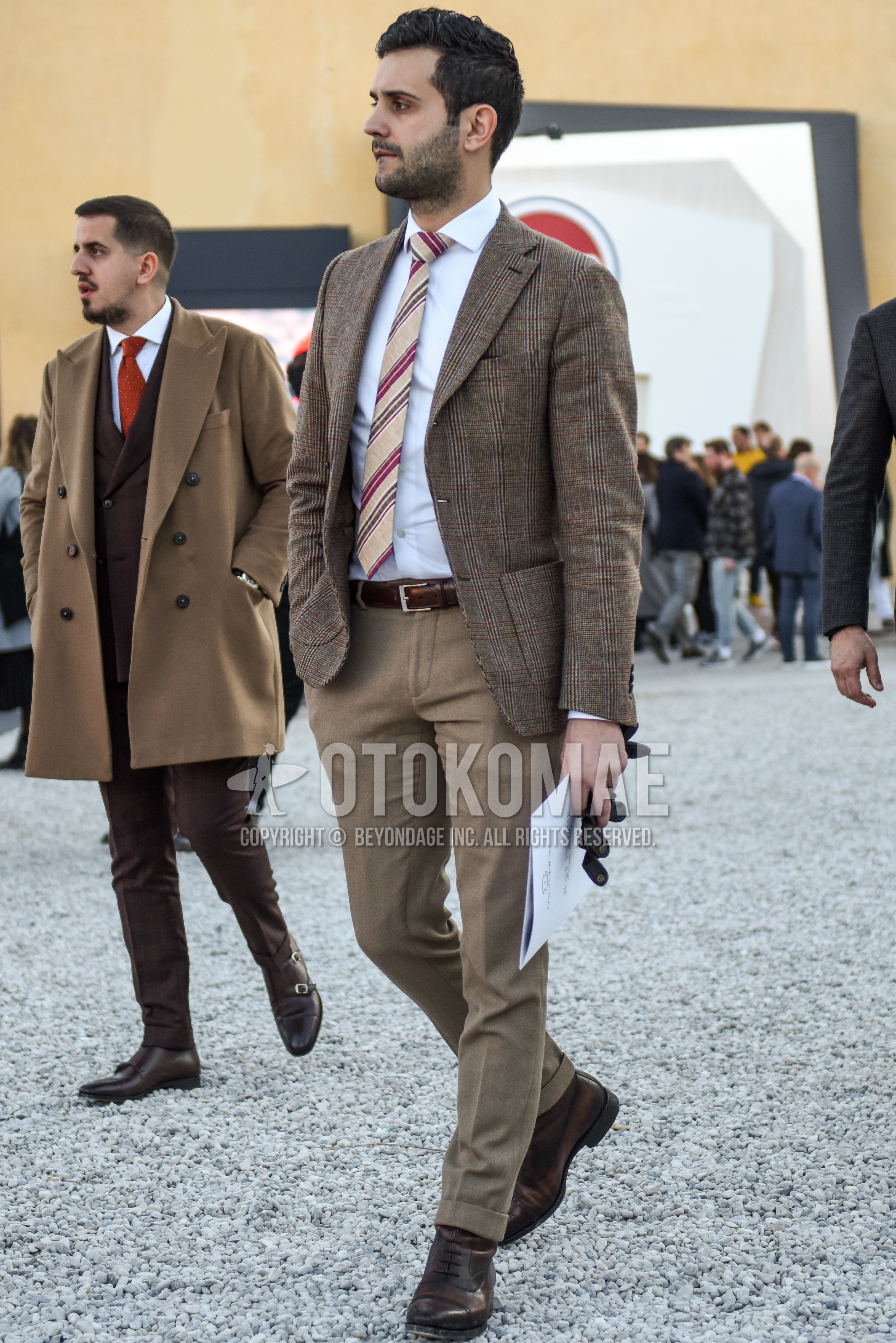 Men's spring autumn outfit with beige check tailored jacket, white plain shirt, brown plain leather belt, beige plain slacks, brown  boots, beige regimental necktie.