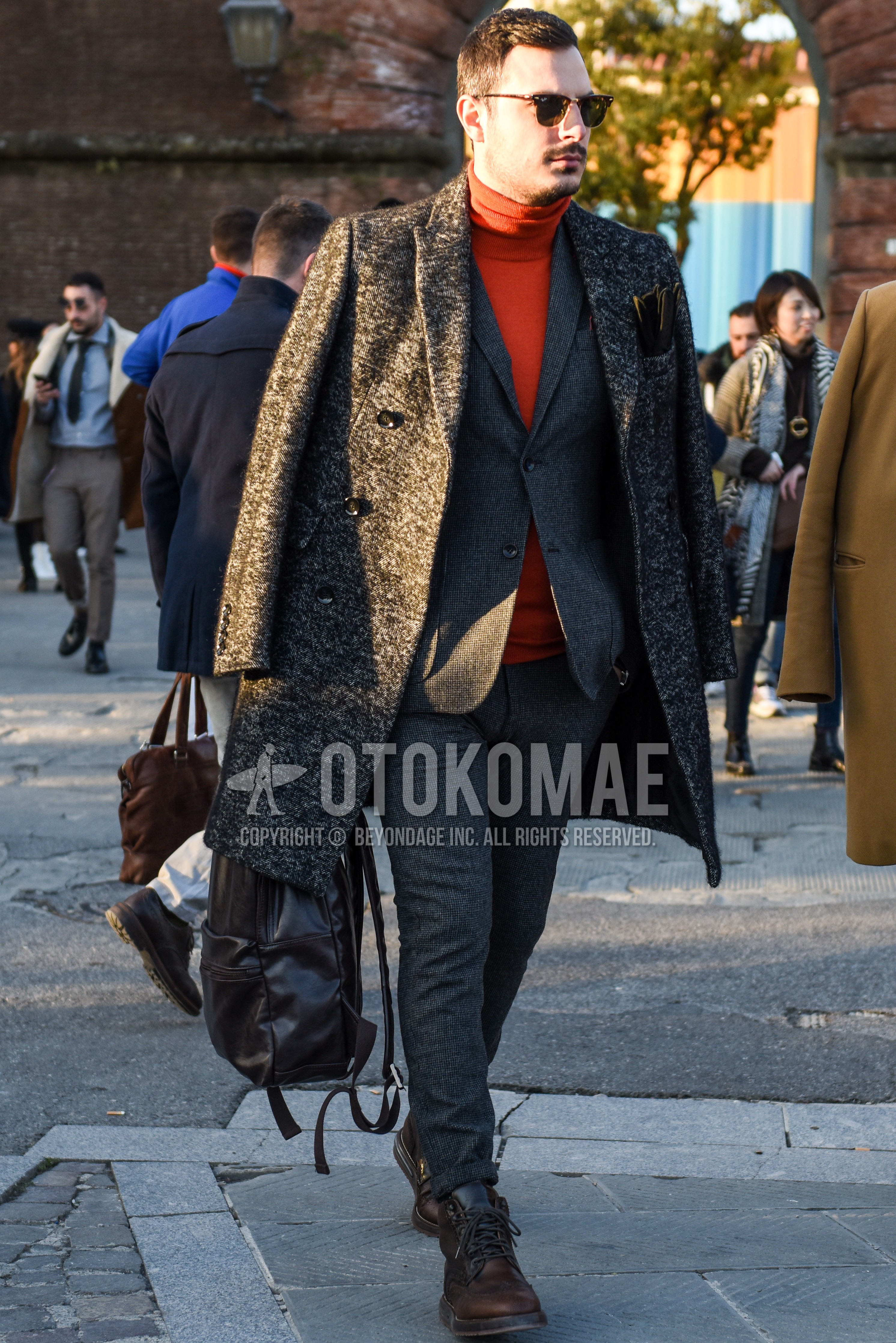 Men's autumn winter outfit with brown tortoiseshell sunglasses, gray outerwear chester coat, orange plain turtleneck knit, brown work boots, gray check suit.