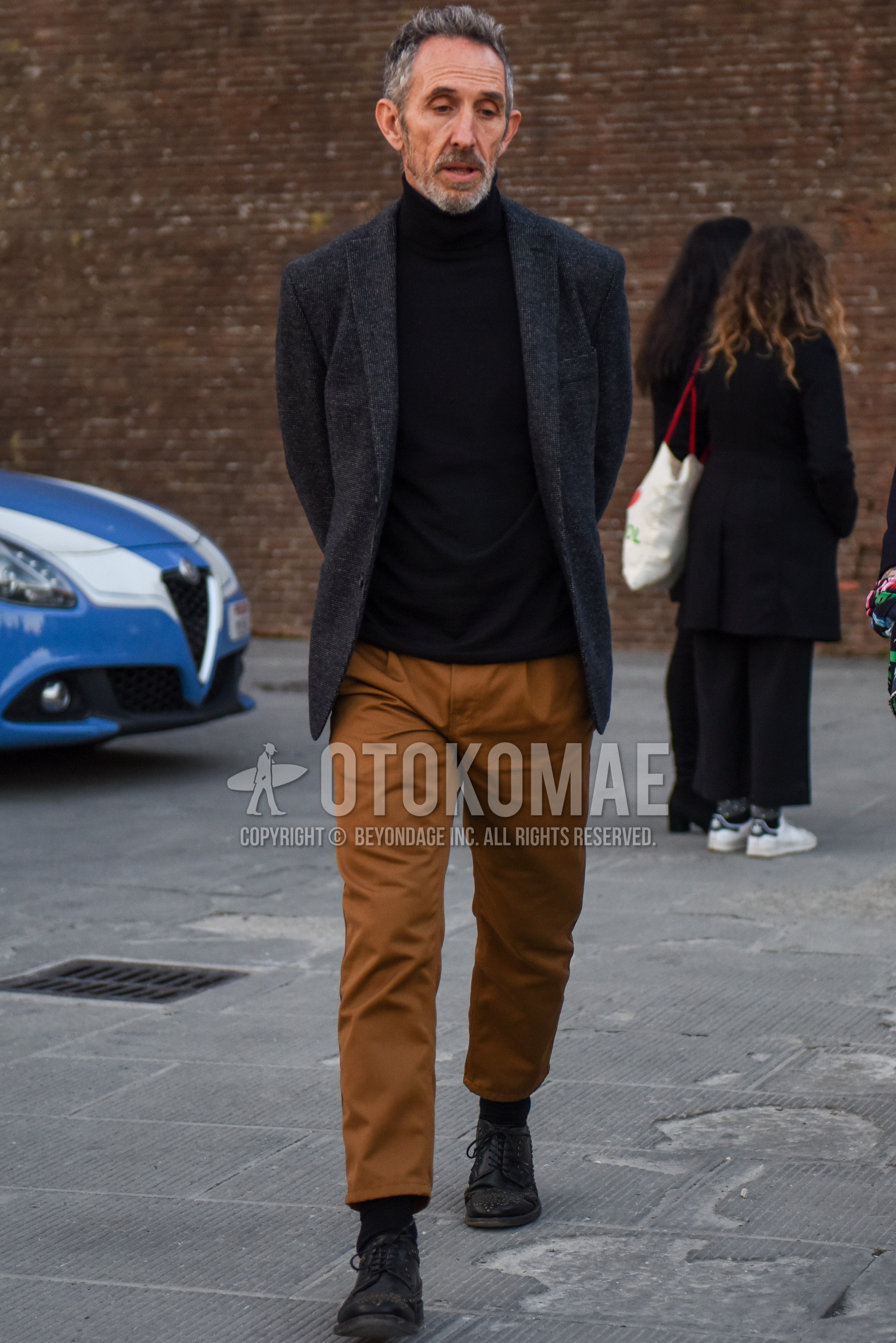 Men's spring autumn outfit with dark gray check tailored jacket, black plain turtleneck knit, beige plain chinos, beige plain ankle pants, black plain socks, black brogue shoes leather shoes.