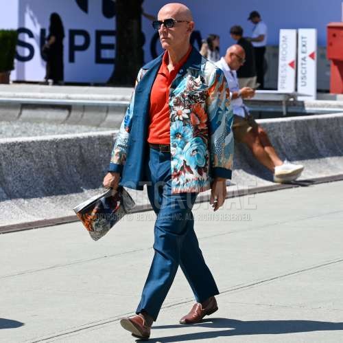 黒無地のサングラス、マルチカラー総柄のテーラードジャケット、オレンジ無地のポロシャツ、ブラウン無地のレザーベルト、ネイビー・ピンクチェックのスラックス、ブラウン無地のソックス、ブラウンの革靴、マルチカラー総柄のクラッチバッグ/セカンドバッグ/巾着を合わせた夏春のメンズコーデ・着こなし。