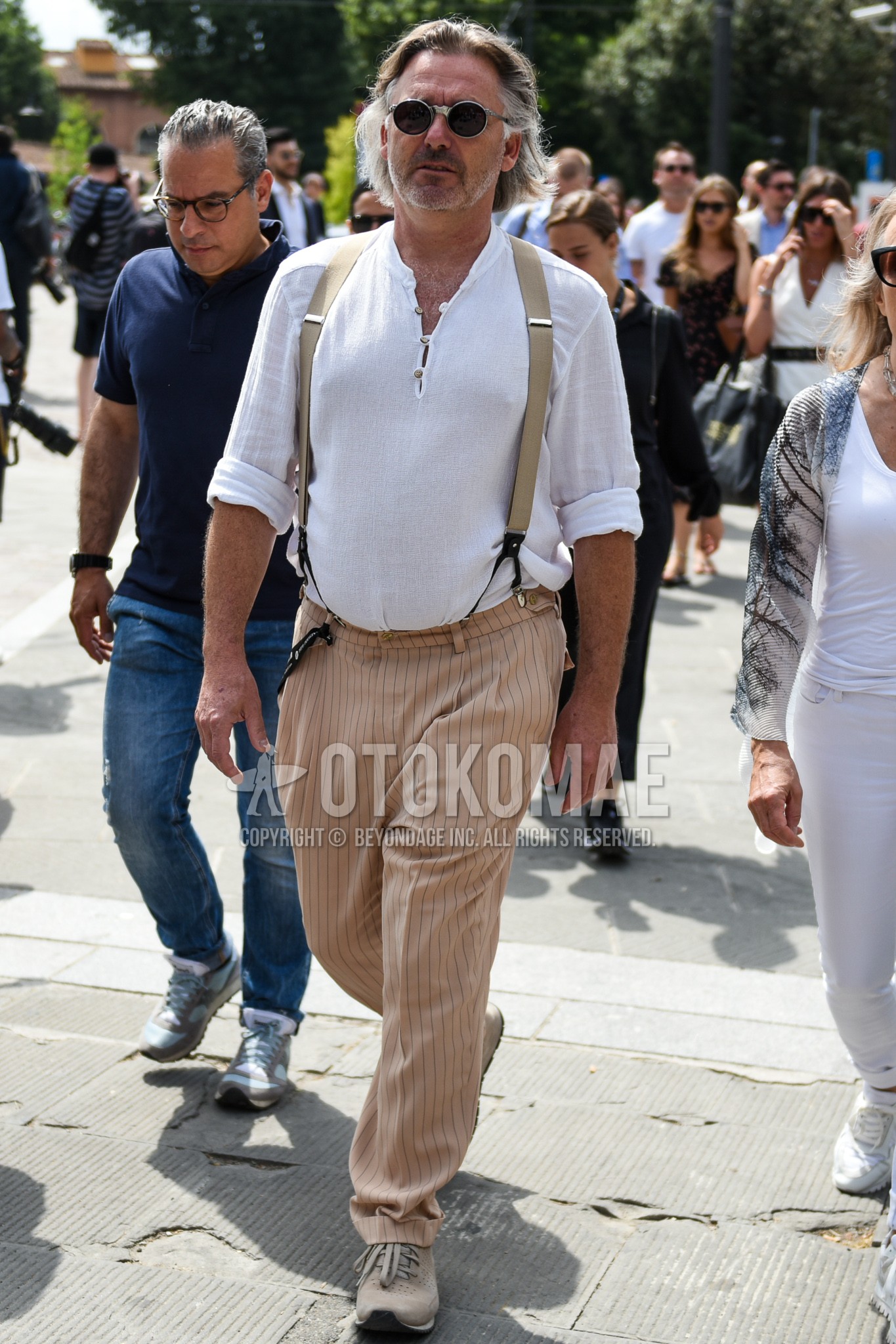 Men's summer outfit with gray plain sunglasses, white plain t-shirt, beige plain suspenders, beige stripes slacks, beige low-cut sneakers.