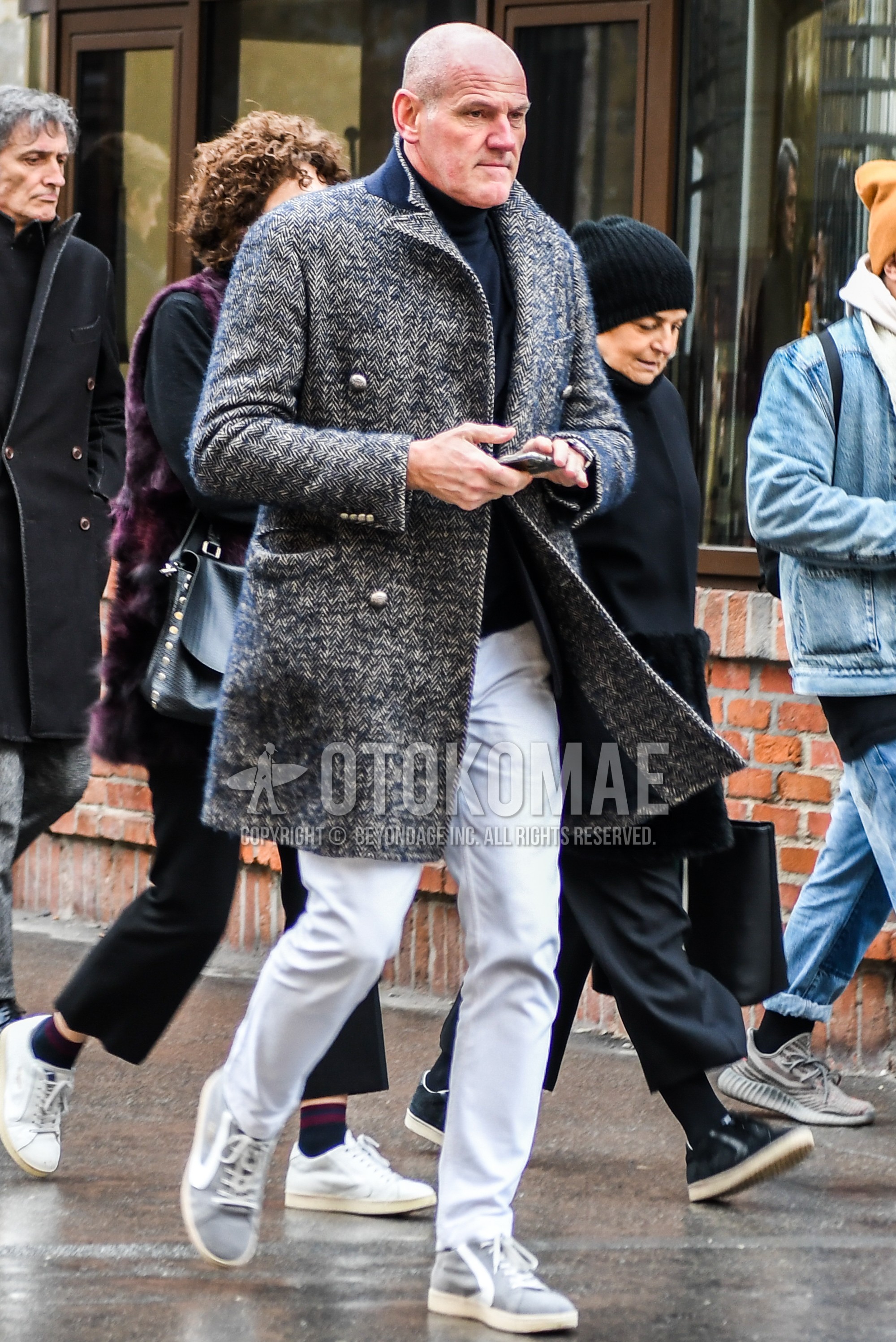 Men's winter outfit with gray herringbone chester coat, black plain turtleneck knit, white plain cotton pants, gray high-cut sneakers.