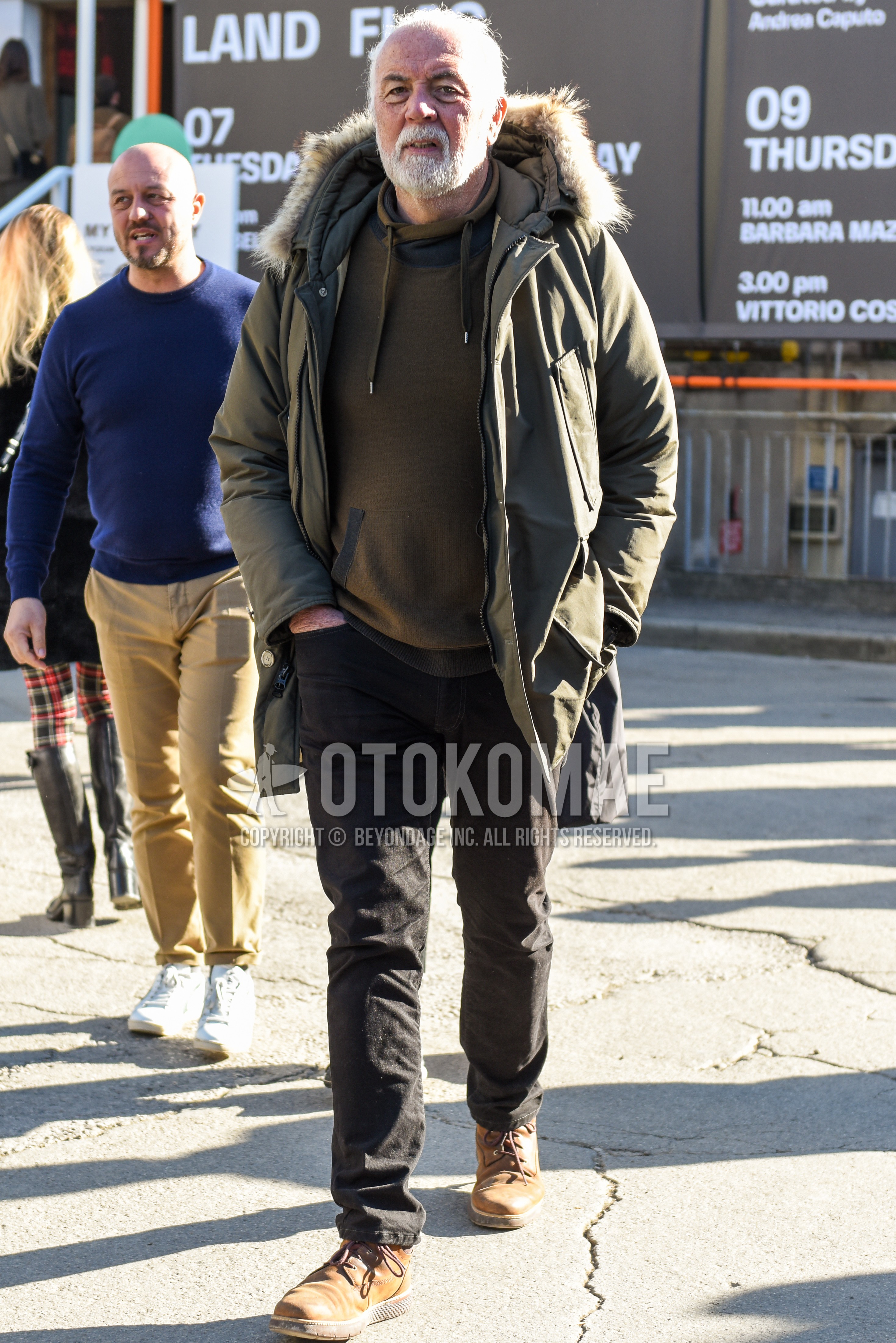 Men's winter outfit with olive green plain down jacket, brown plain hoodie, black plain chinos, brown  boots.