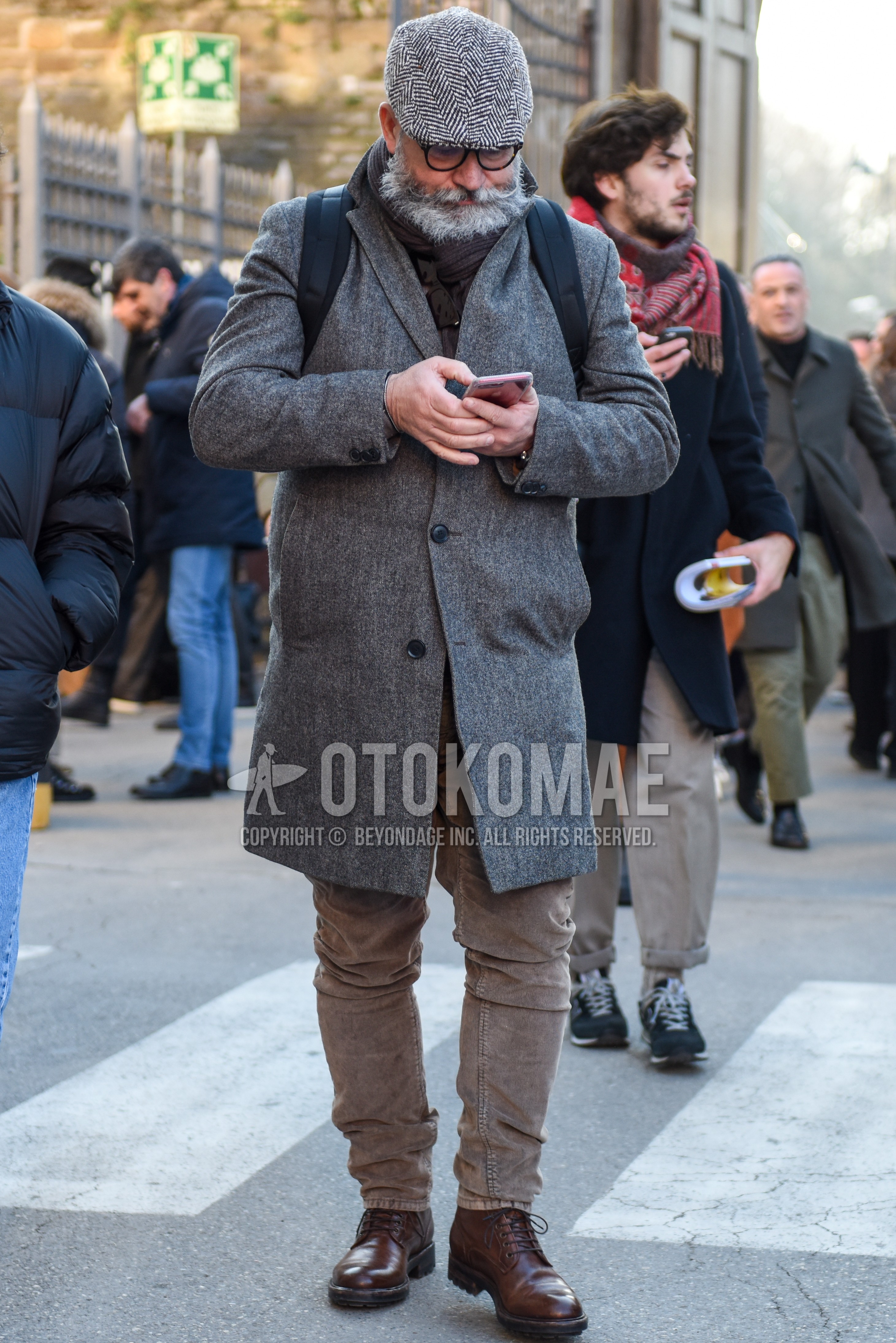 Men's autumn winter outfit with gray herringbone hunting cap, black plain glasses, gray plain scarf, gray plain chester coat, beige plain winter pants (corduroy,velour), brown  boots.