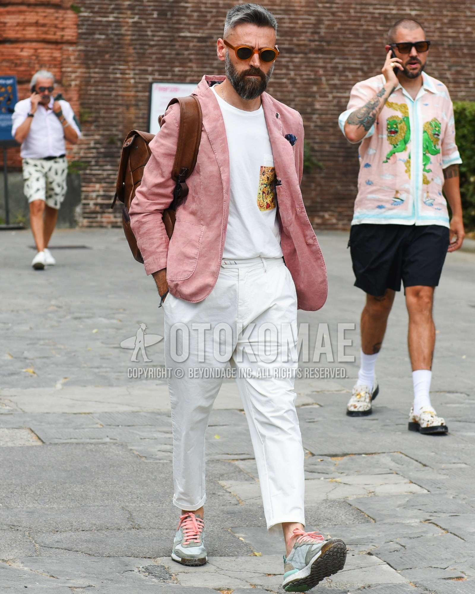 Men's spring summer outfit with brown plain sunglasses, pink plain tailored jacket, black tops/innerwear t-shirt, white plain slacks, gray low-cut sneakers, brown plain backpack.