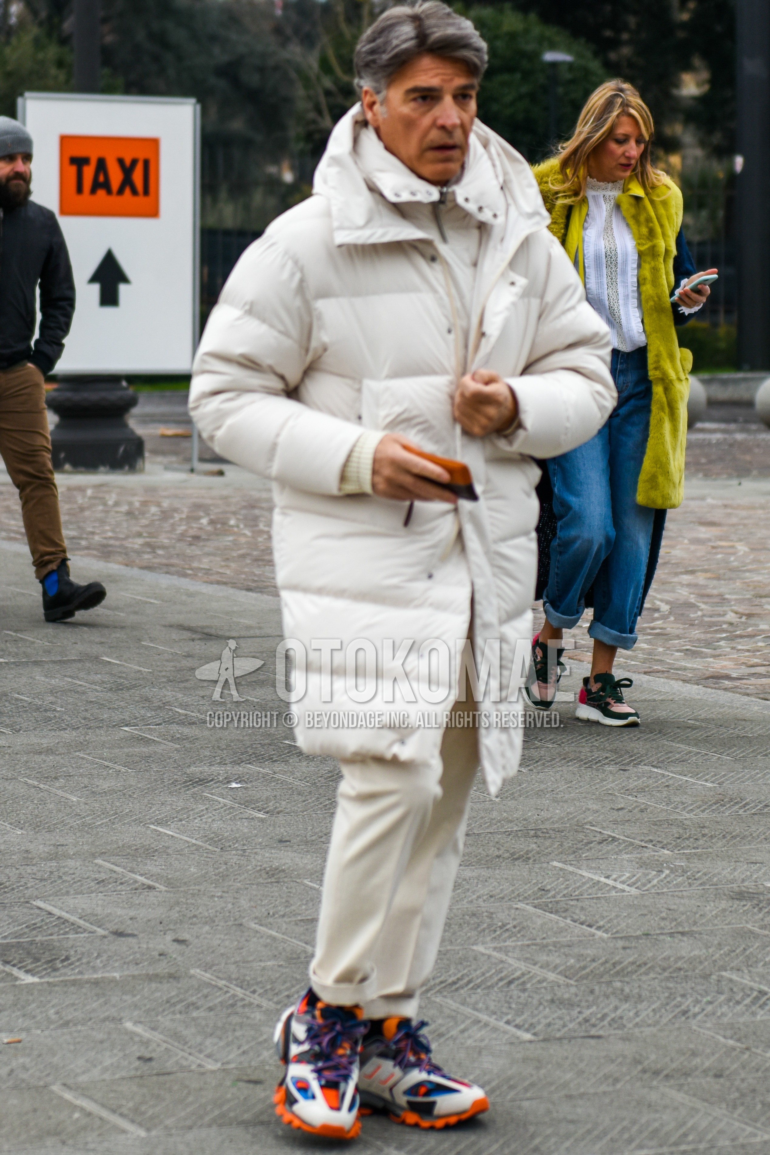 Men's autumn winter outfit with white plain down jacket, white plain inner down, white plain slacks, multi-color low-cut sneakers.